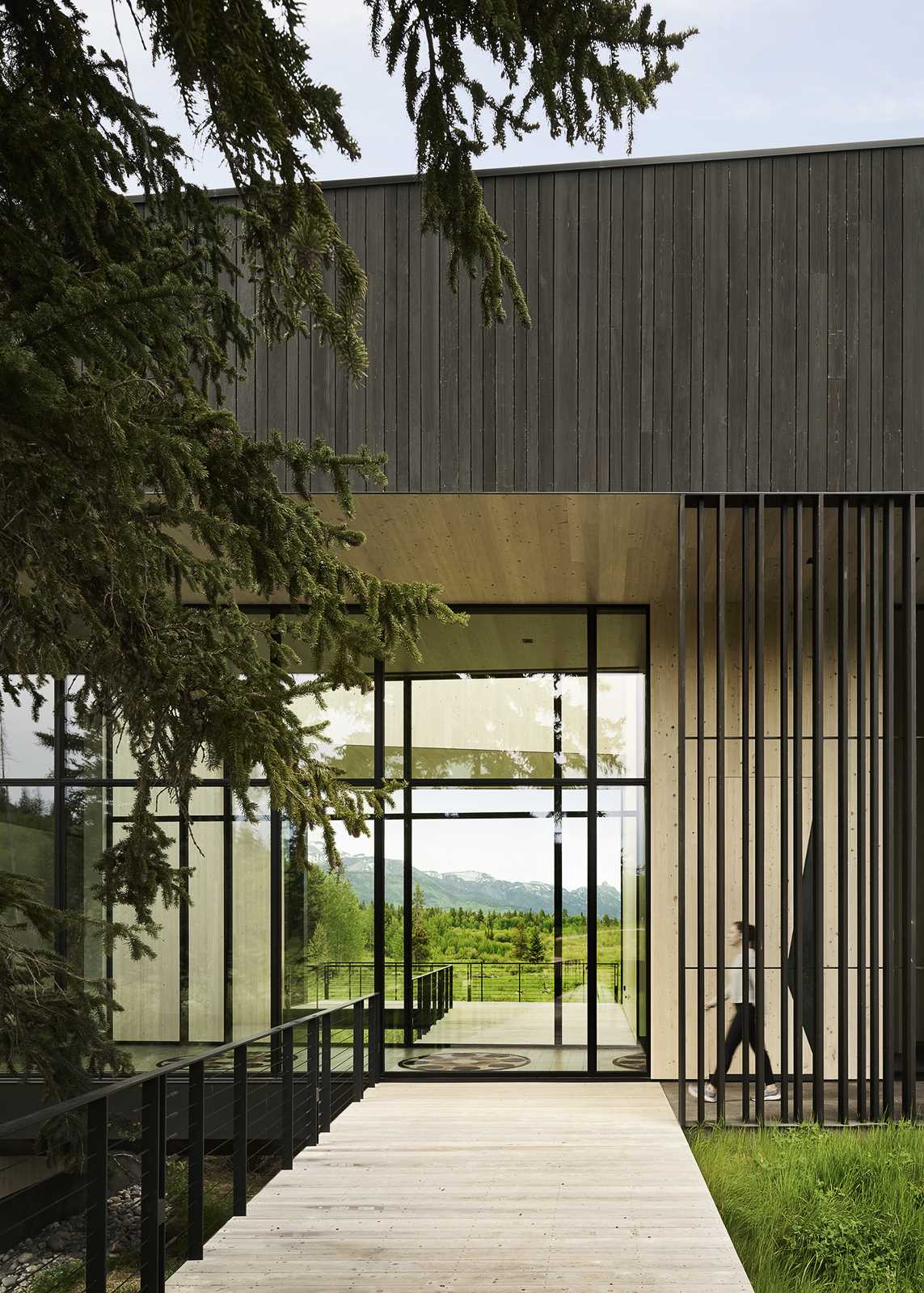 The entrance to the home is located where the structure reaches out over a lowland creek, while the wood exterior wraps into the interior as light Atlantic cedar.