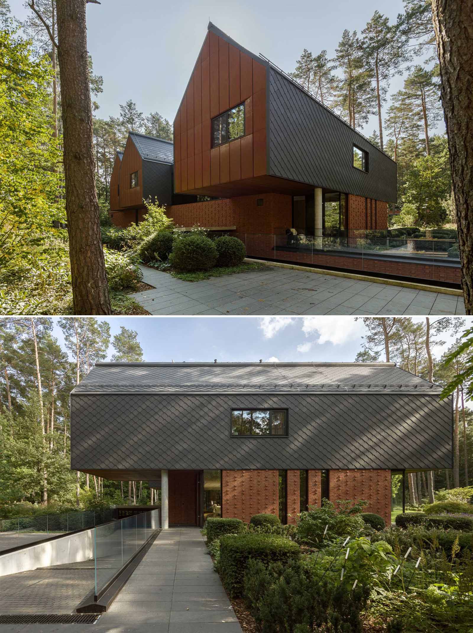 A modern home in the forest, features gabled forms, red brick, black-coated tiles, and an weathered steel on its exterior.