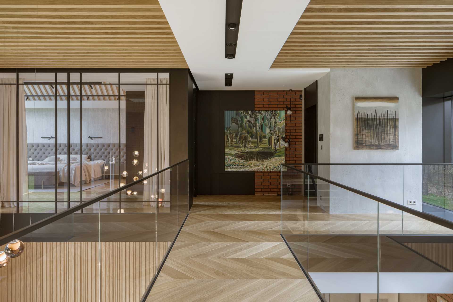 An elevated walkway with glass railings connects the various areas of this modern home.