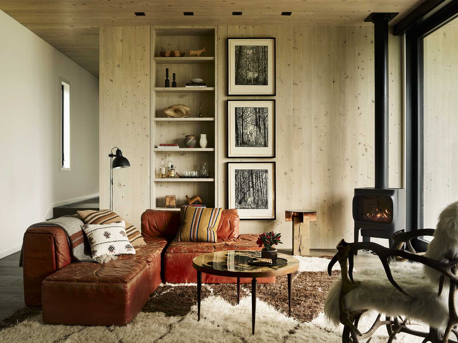 In this living room, a fireplace is positioned in the corner, while artwork is mounted next to built-in shelving.