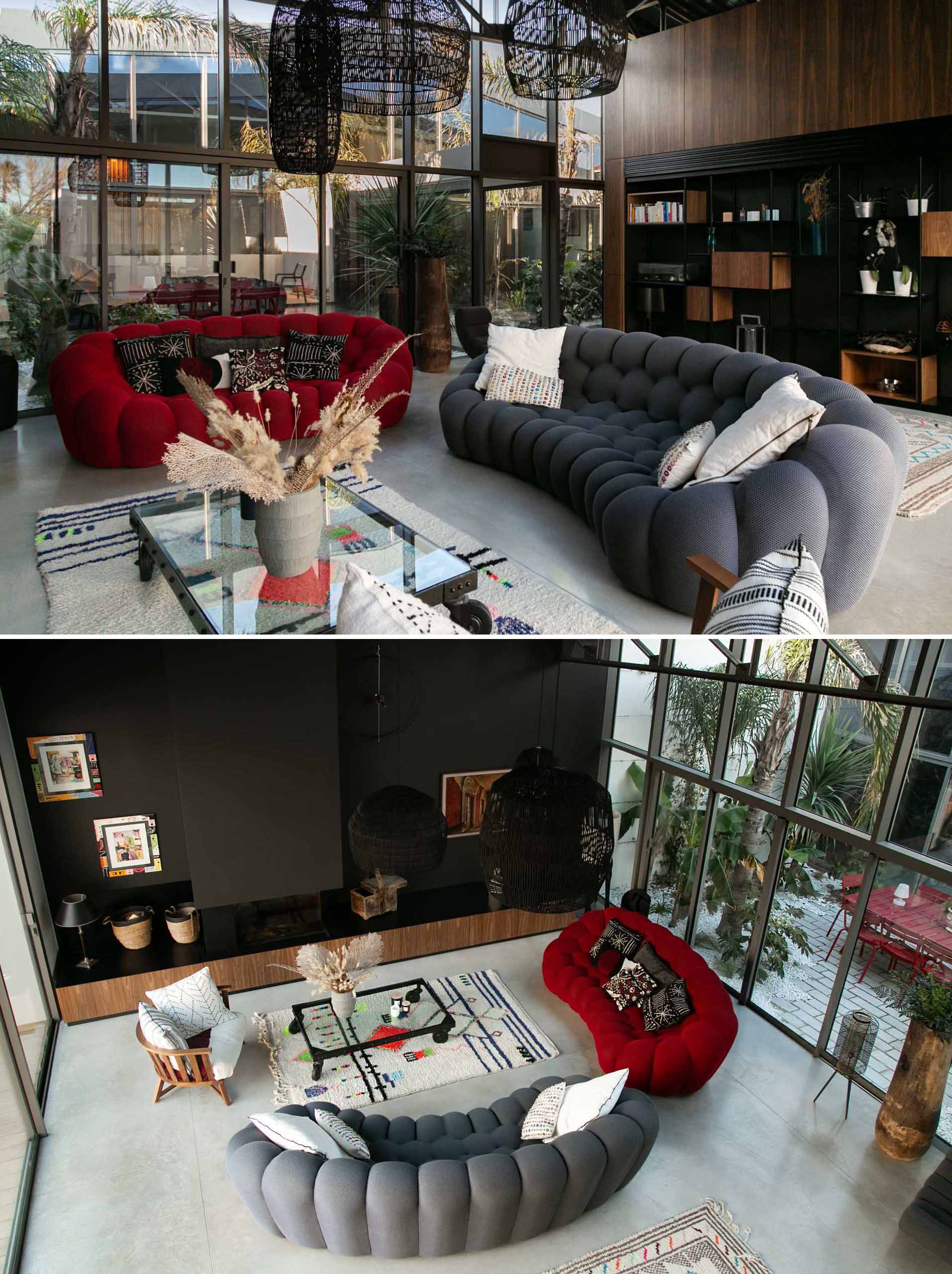 In this modern living room in a warehouse conversion, a library built-in library adds storage, while a pop of color has been added to the space in the form of a red couch, while a storage unit runs along the wall.