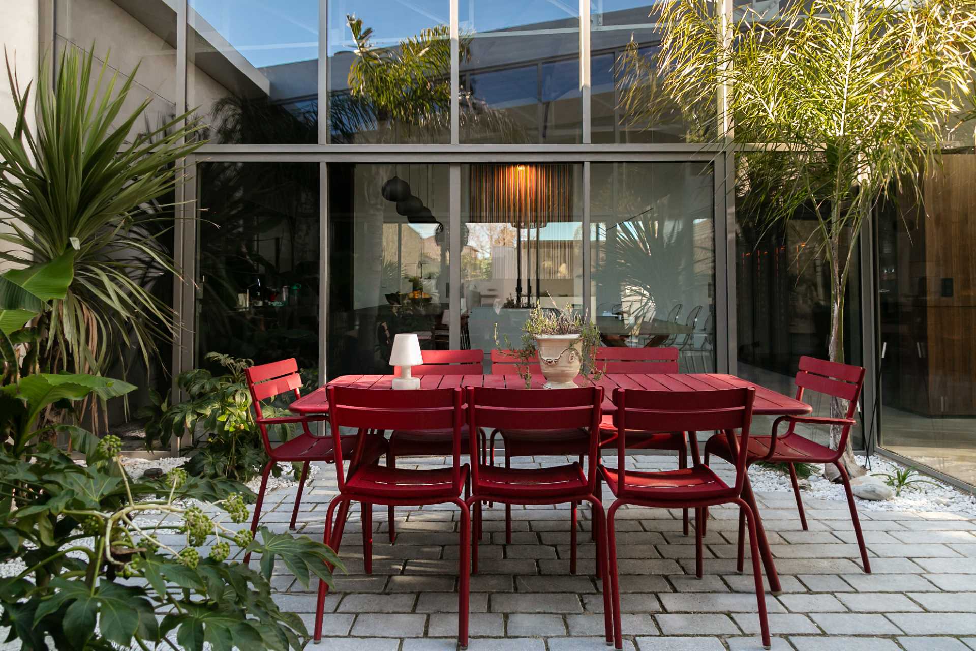 A modern patio furnished with red outdoor furniture.