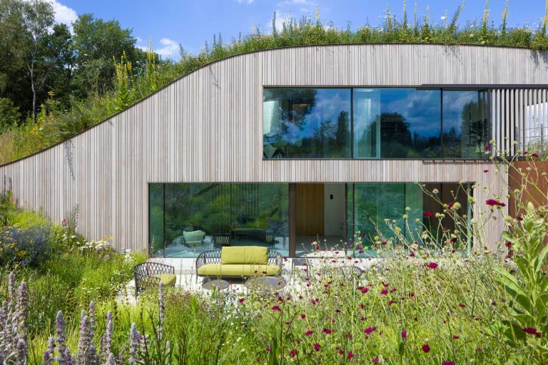 A House Built Into The Ground And Covered In Flowers