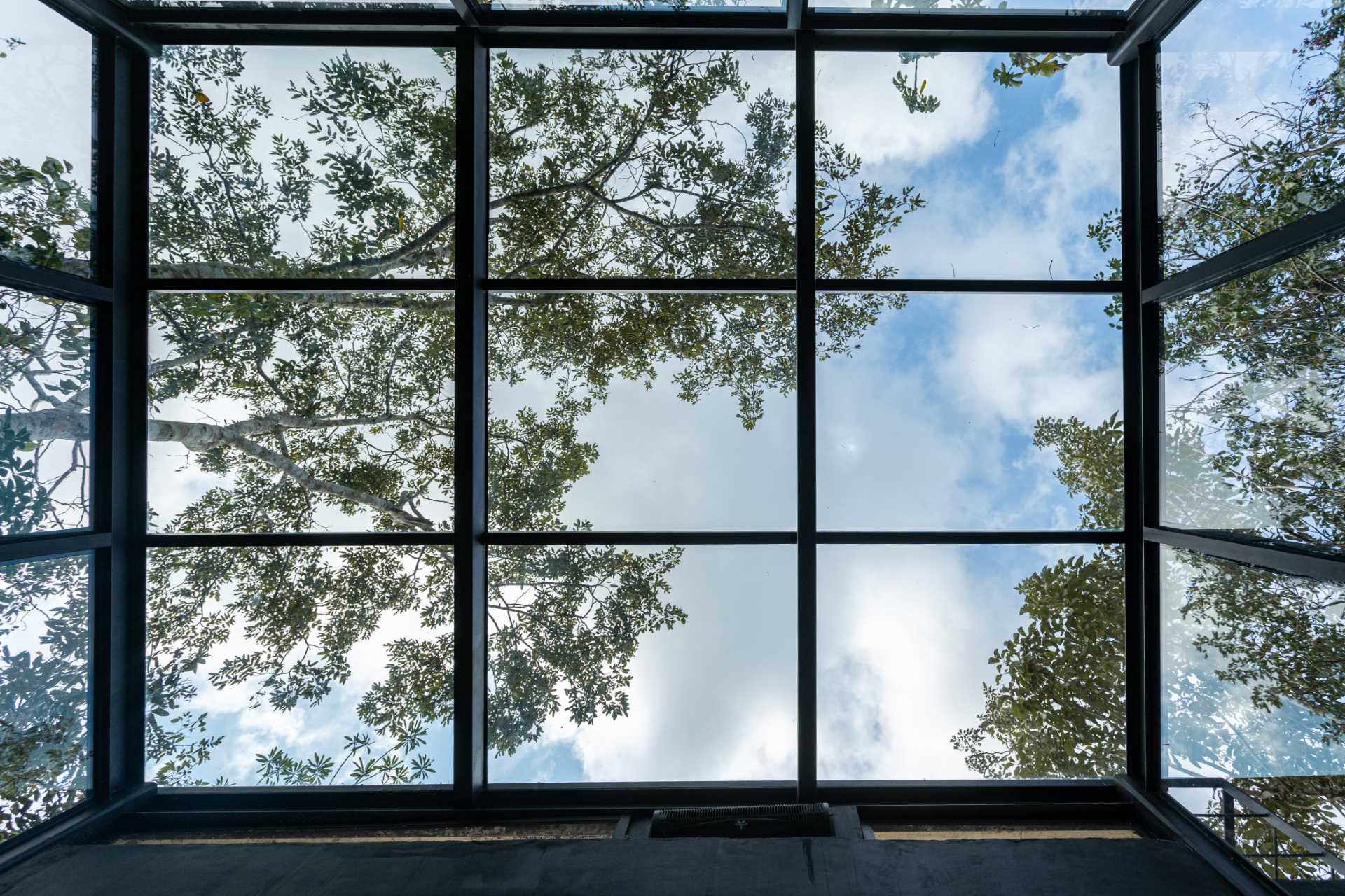 The black-framed windows and sliding walls of the bedrooms in this off-grid cabins, allow the guests to feel like they are sleeping within the dense jungle and are one with nature.