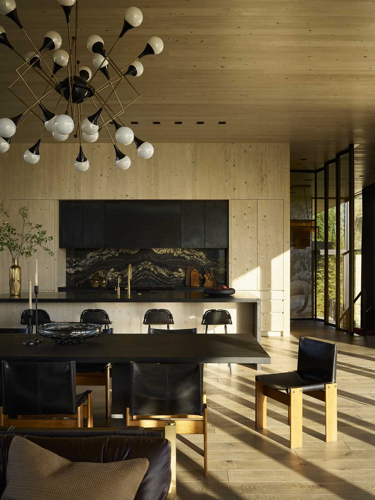 The dining room, which features a chandelier from Jean-Marc Frey, separates the living room from the kitchen.