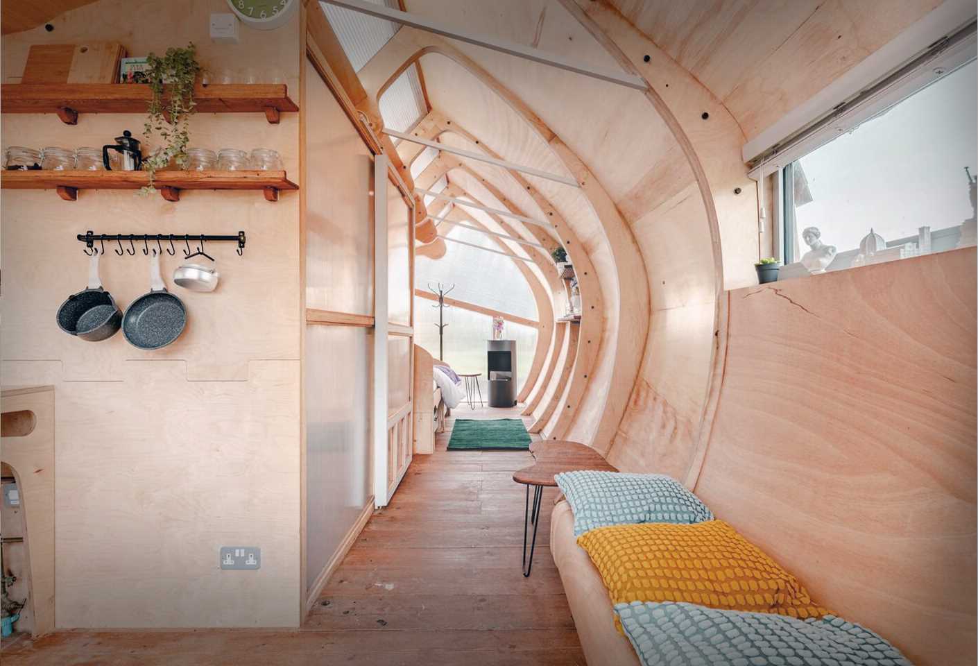 A small ،ically shaped cabin clad in wood ،ngles.