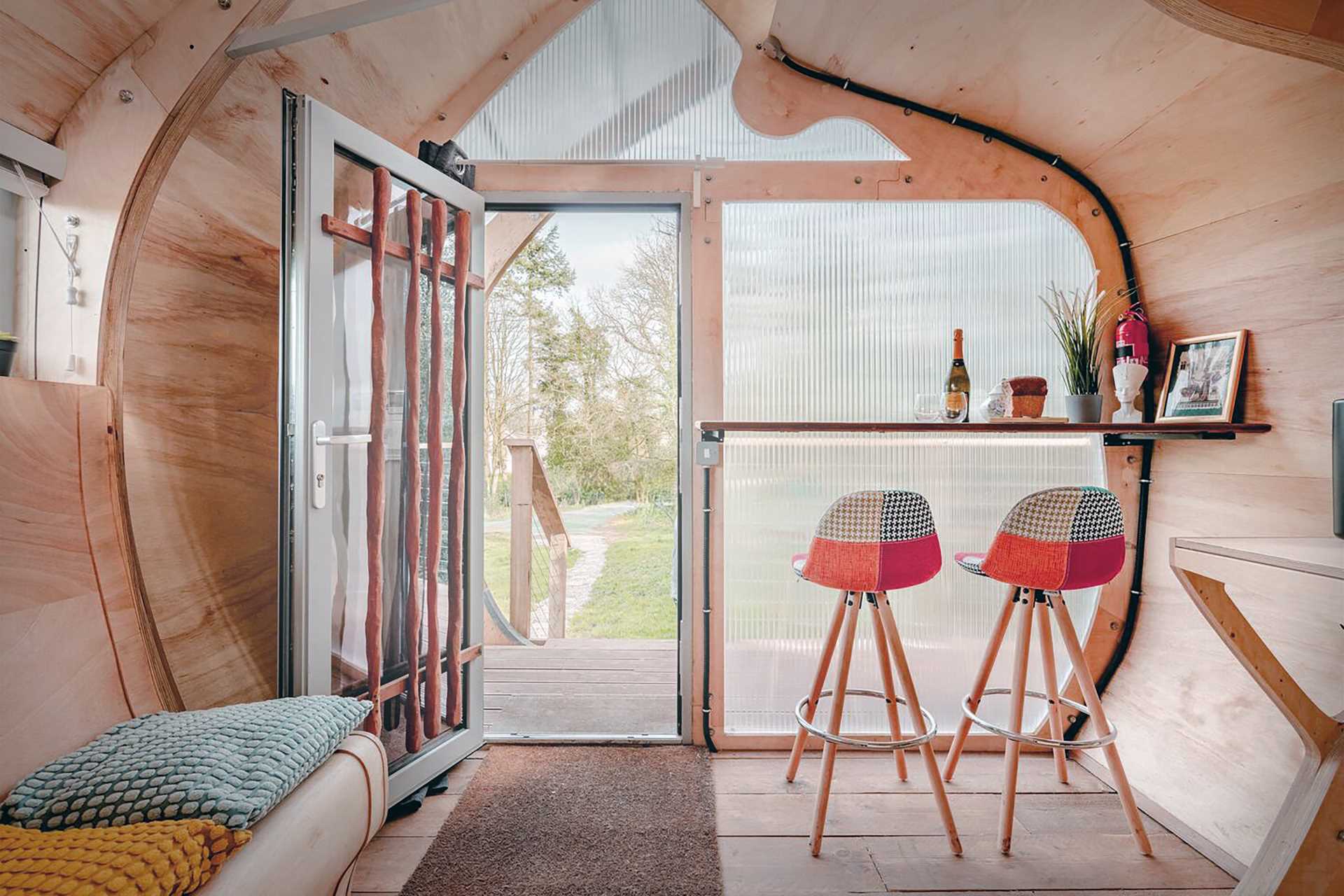 A small organically shaped cabin clad in wood shingles.