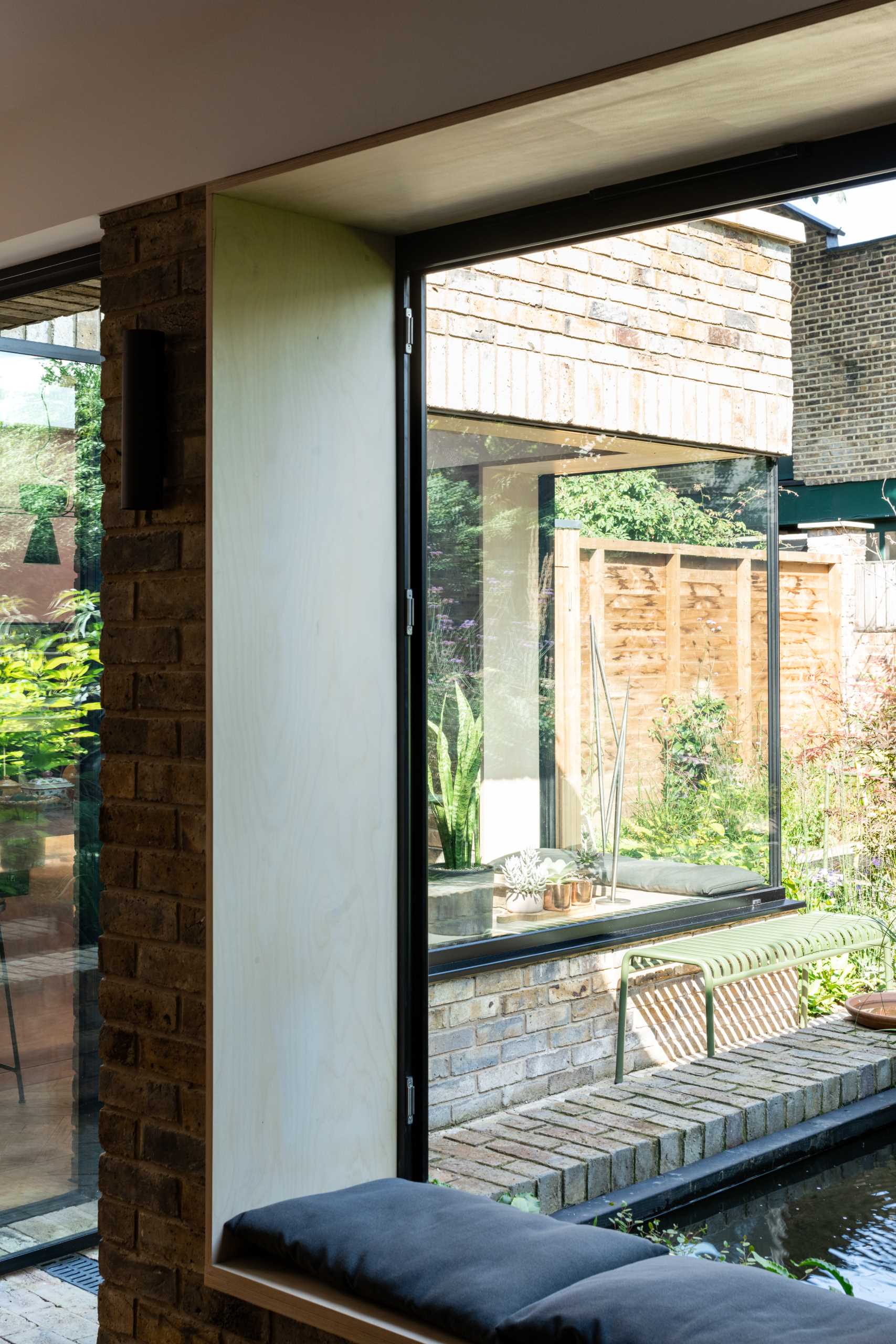 A brick home extension with a blush pink kitchen and window seats.