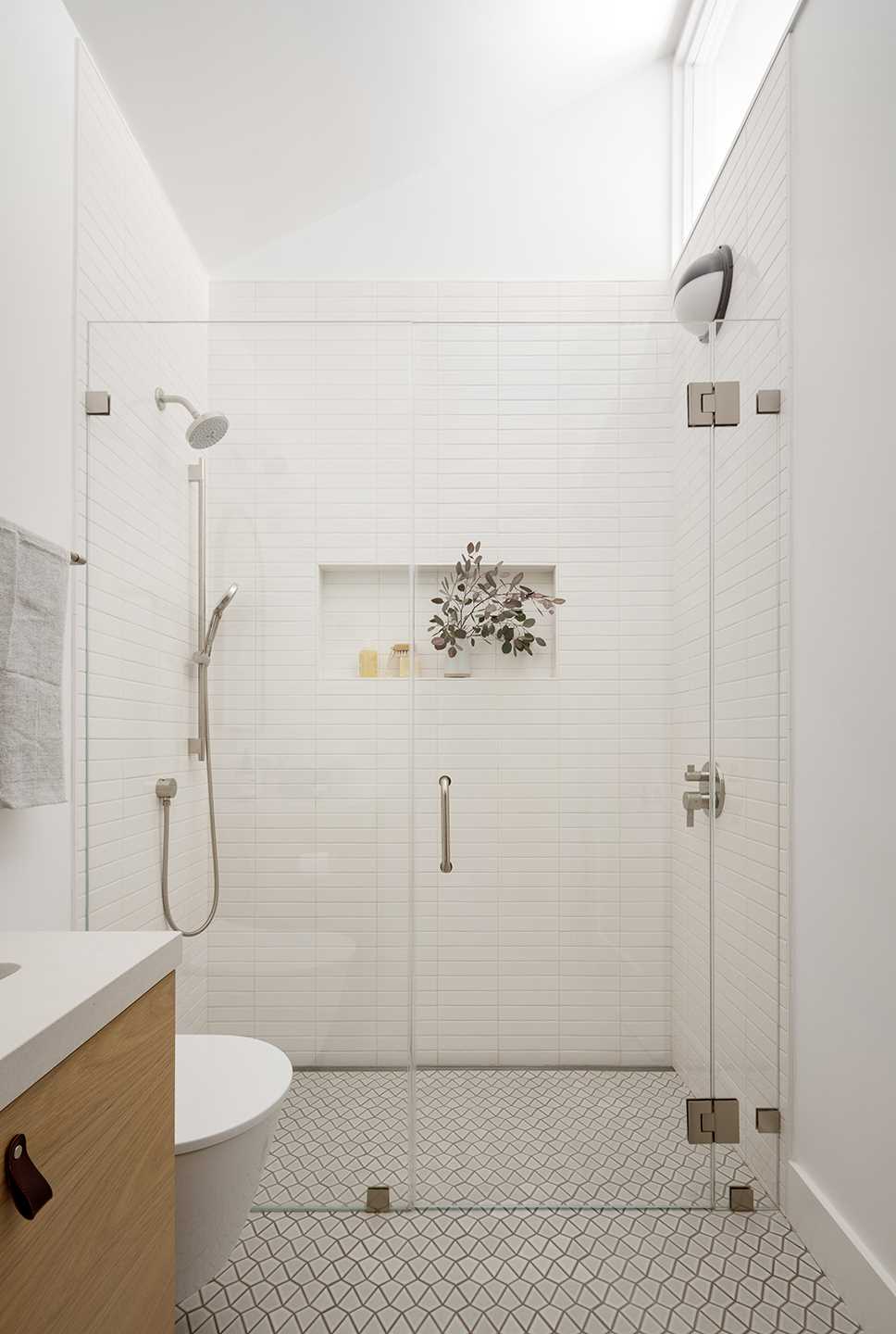 A modern shower with a simple color palette and shelving niche.