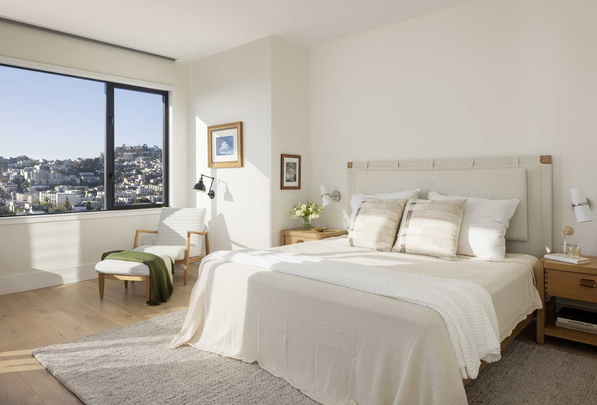 In a bedroom with wood floors, the color palette has been kept neutral to allow the views to be the focal point.