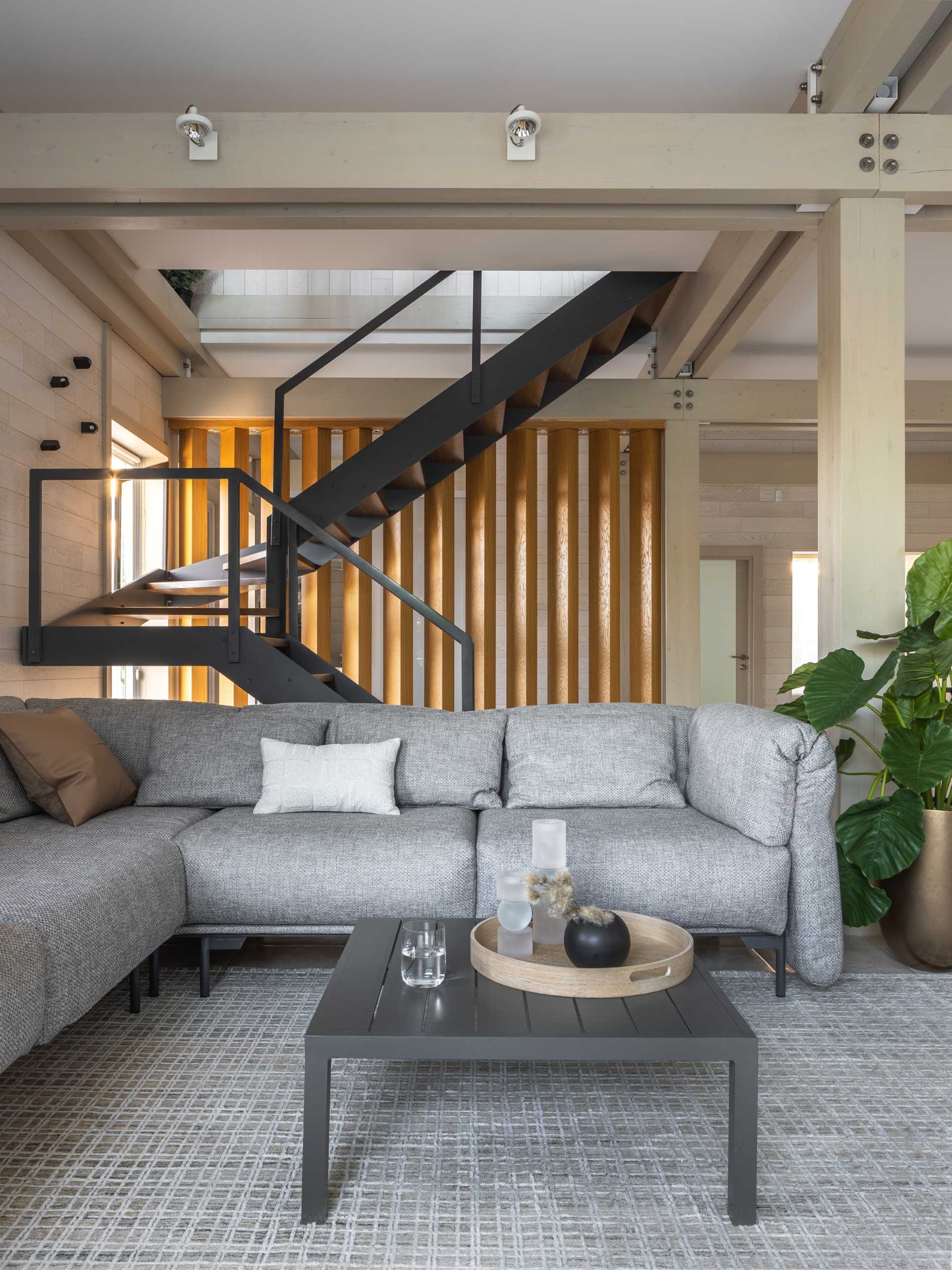 A contemporary living room with exposed posts and beams.