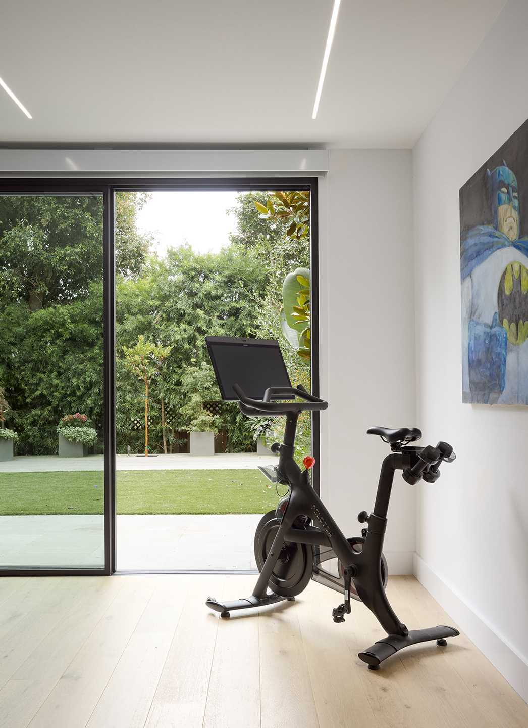 A modern basement used as a workout space opens up to the backyard.