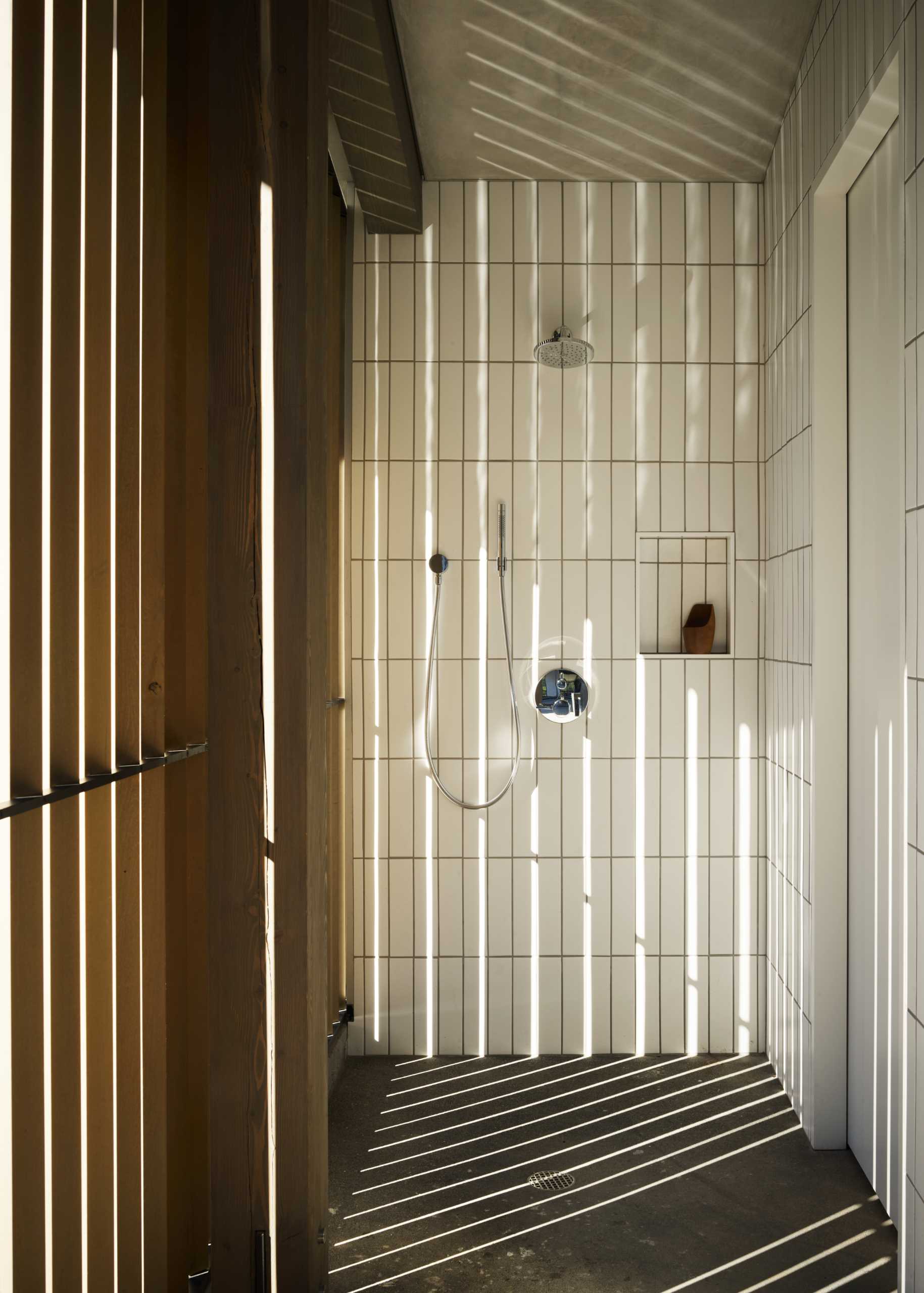 This bathroom has walls covered in vertical tiles which contrast the wood details.