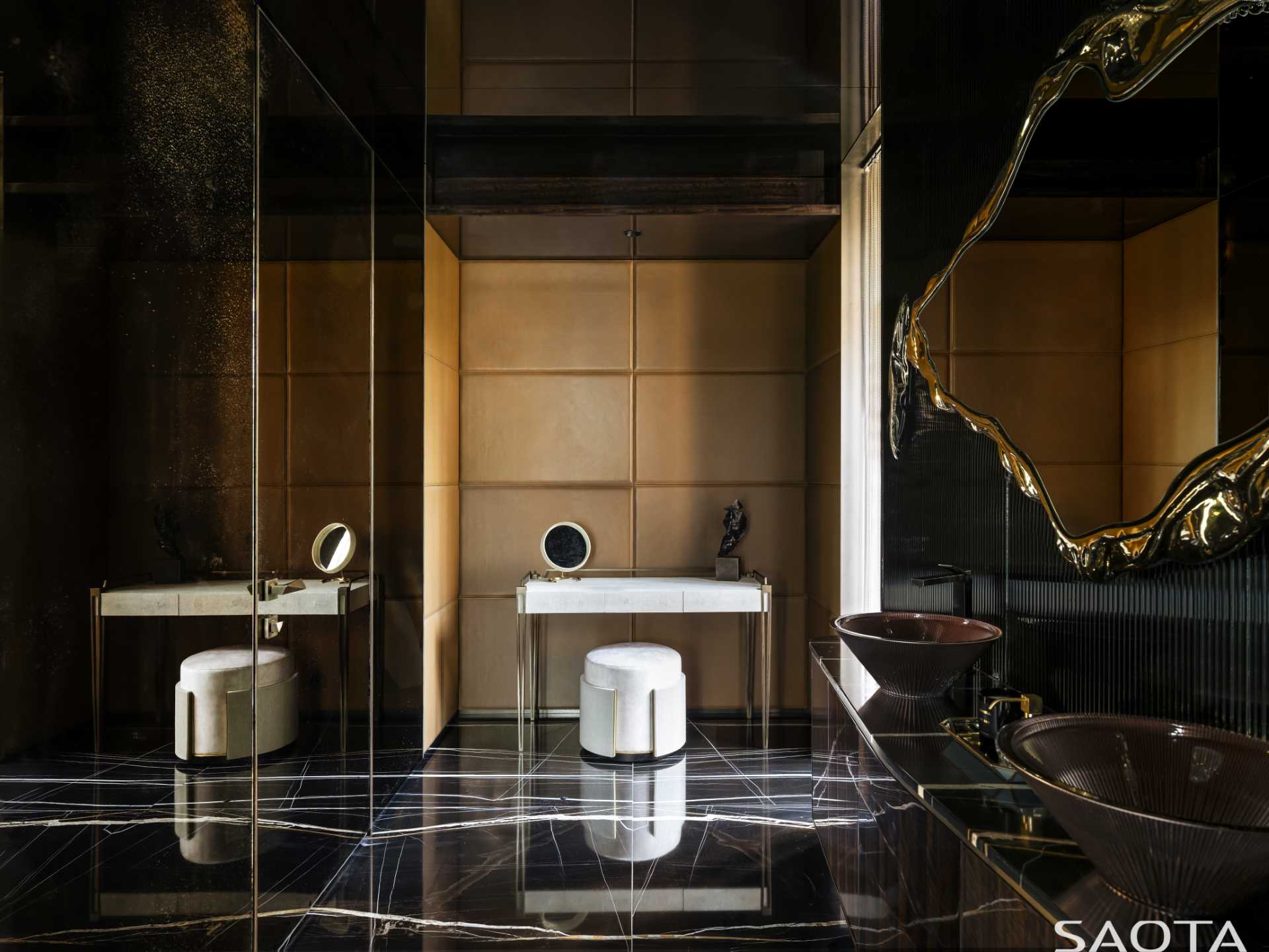 The bathroom with its dark walls and floor, has metallic accents for a luxurious touch.