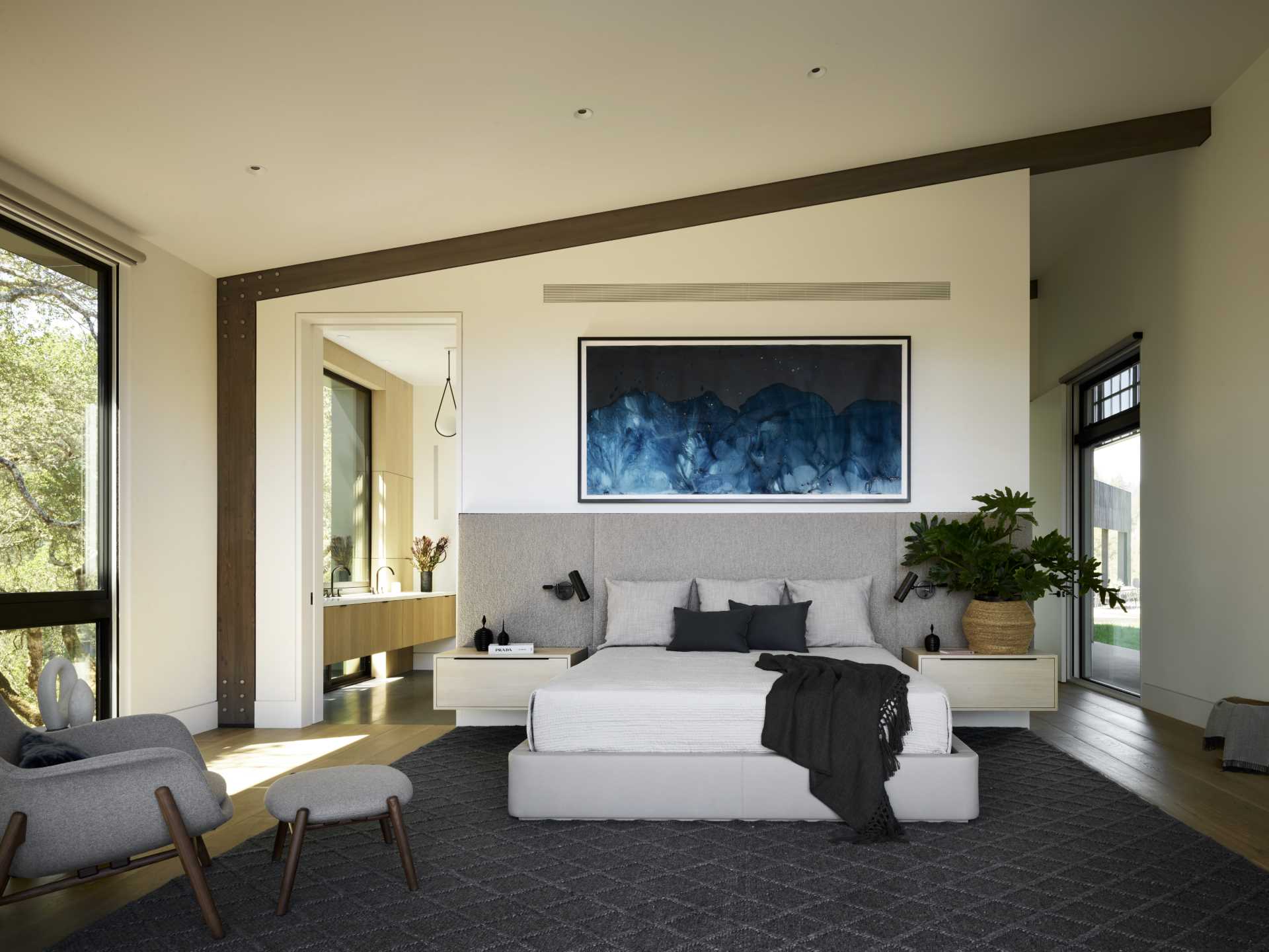 A modern bedroom with exposed wood beams.