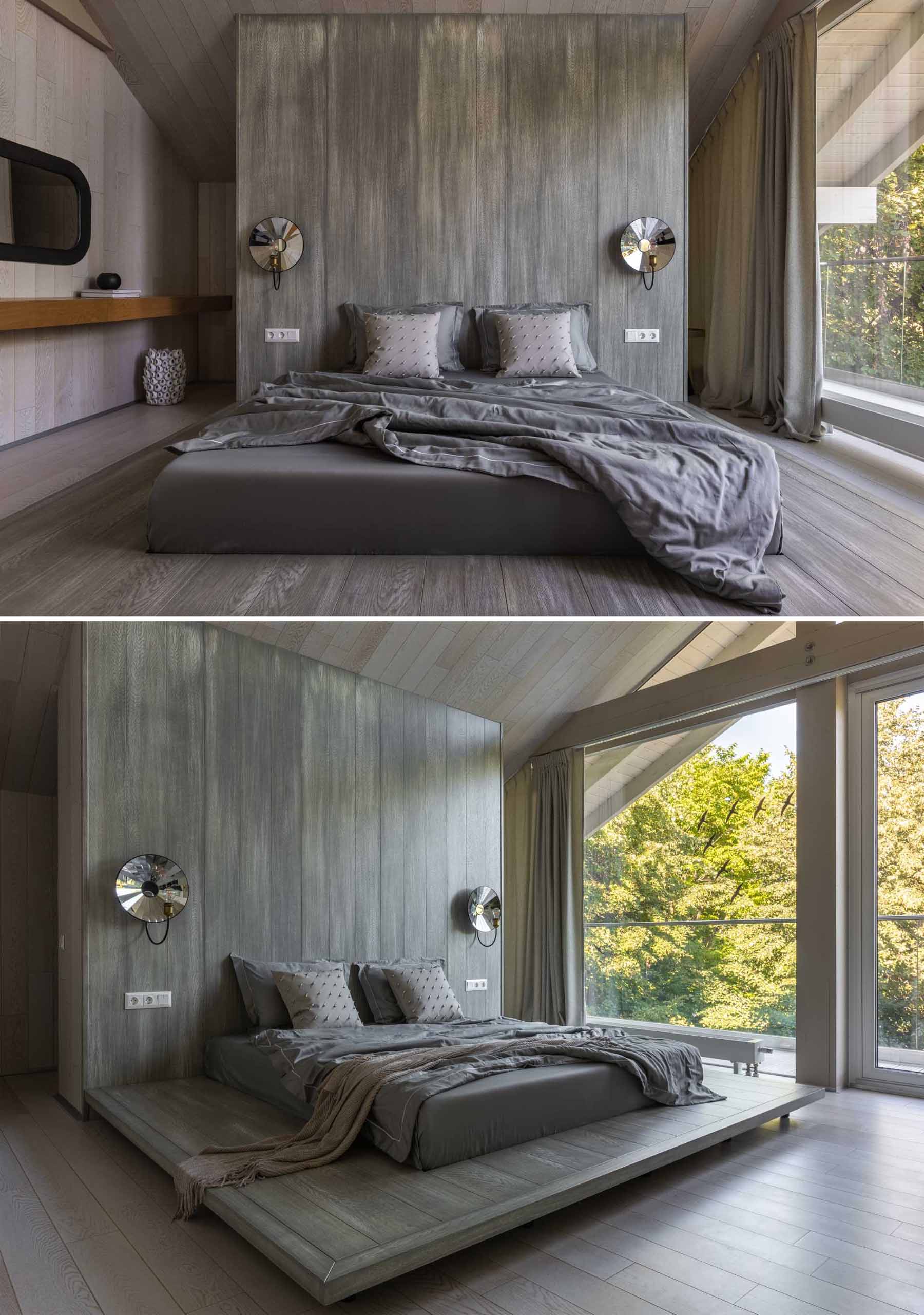 In this contemporary bedroom.,the grey color palette contrasts the lighter areas of the home, while floor-to-ceiling windows fill the room with ample natural light.