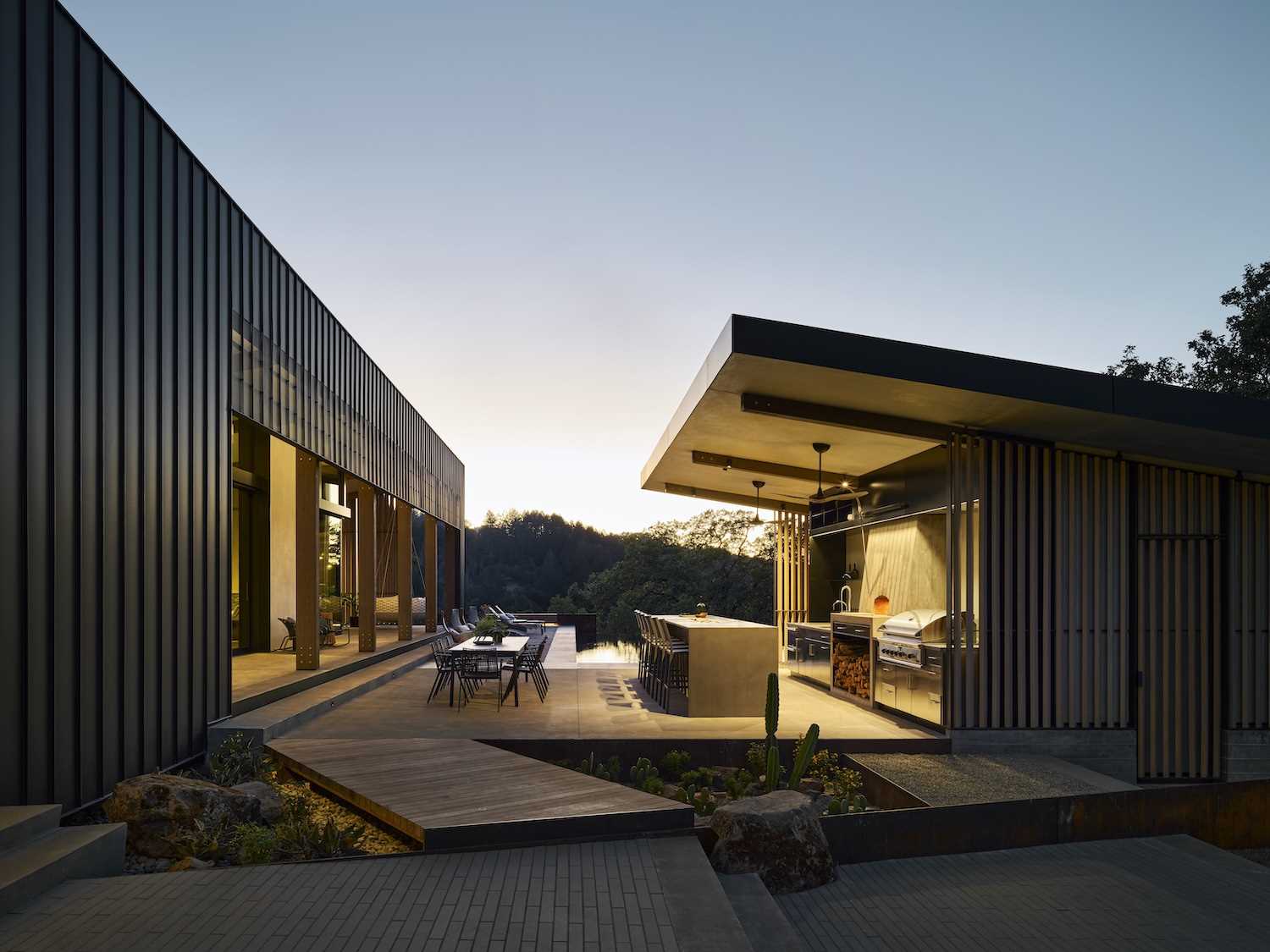 A modern home with a pitched ceiling, exposed wood beams, and expansive outdoor living spaces.