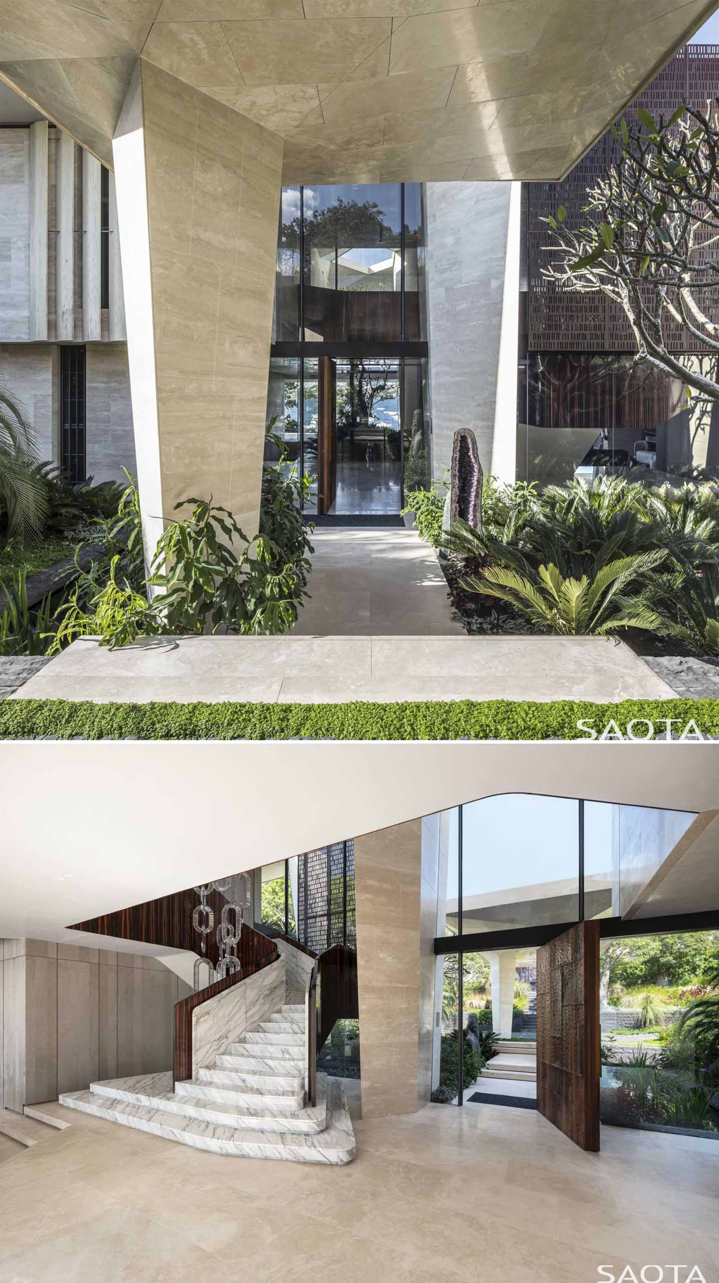 The house has a sculpted stone form that leads to the front door and foyer. From the foyer, views of the water and a tree are visible.