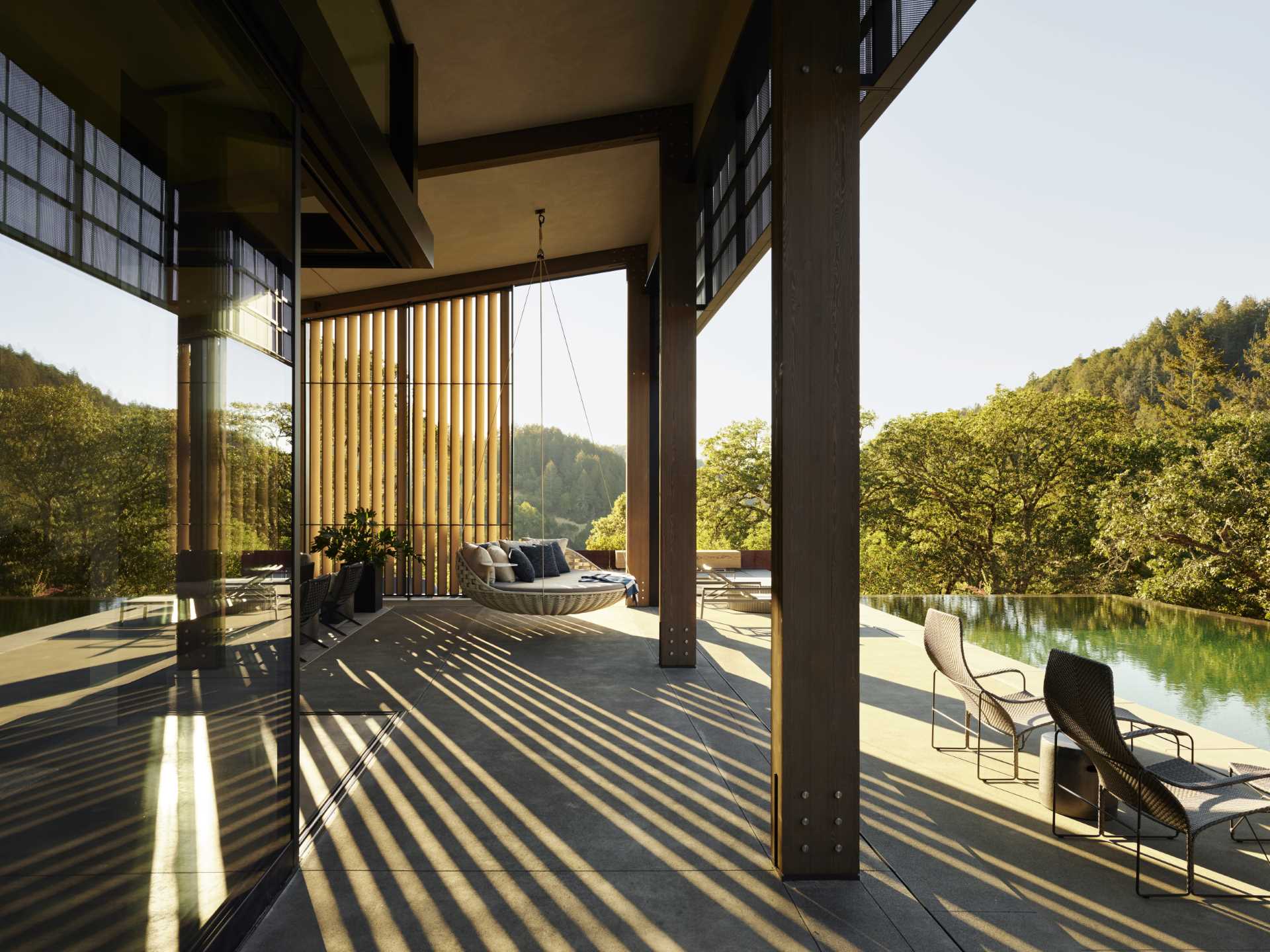 A modern home with a pitched ceiling, exposed wood beams, and expansive outdoor living spaces.