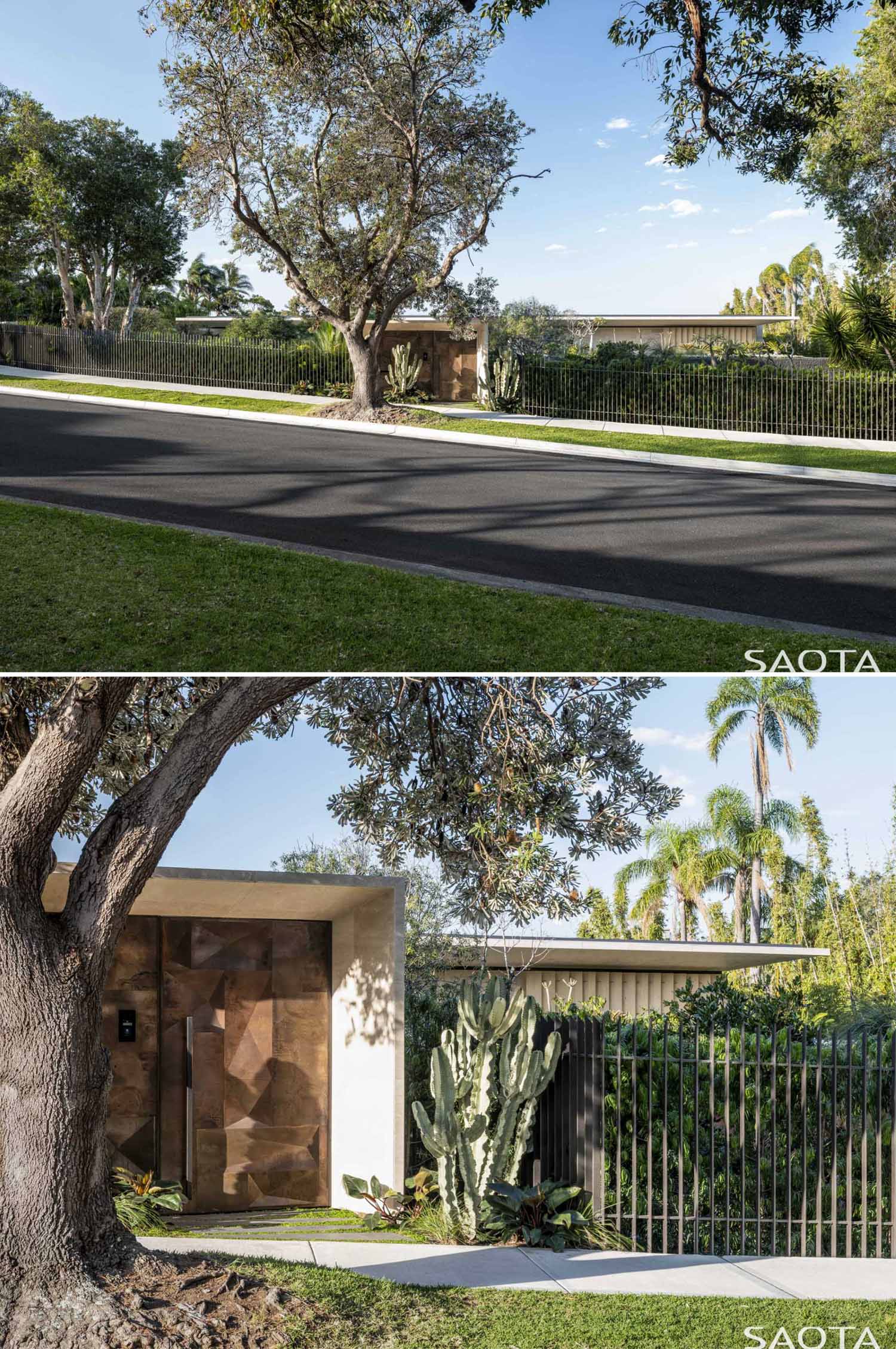 Partially hidden from view from the street, the home, which is located in a historical suburb, sits behind a row of plants and a fence with a unique artistic gate.