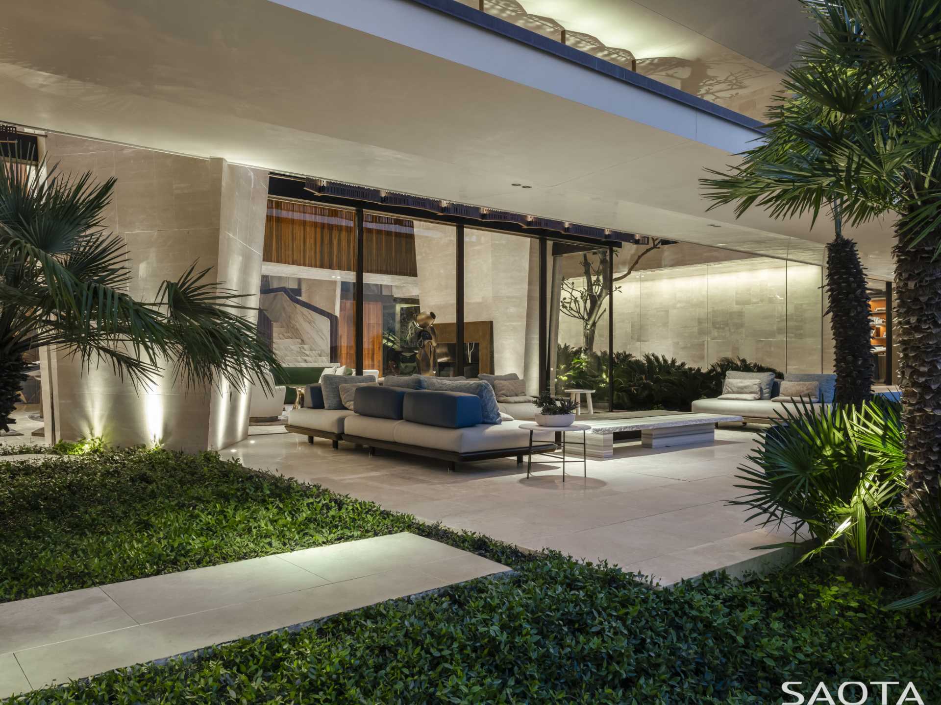 An outdoor living room surrounded by landscaping.