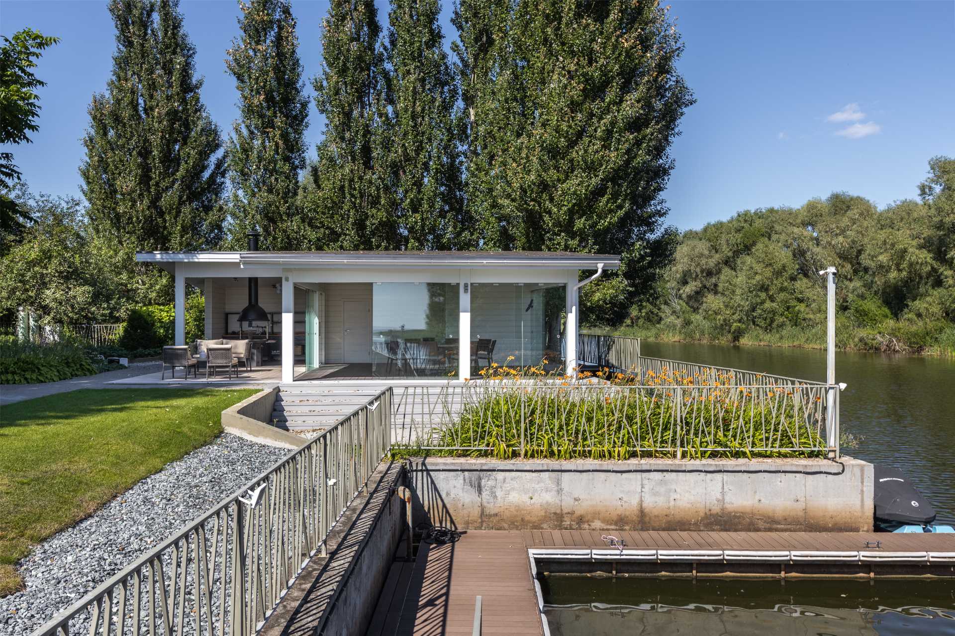 An outdoor pavilion that includes a kitchen with bbq, a covered dining area, and a lounge area.