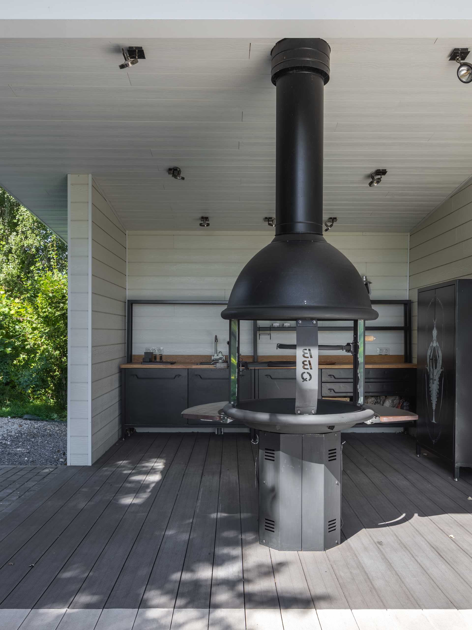 An outdoor pavilion that includes a kitchen with bbq, a covered dining area, and a lounge area.