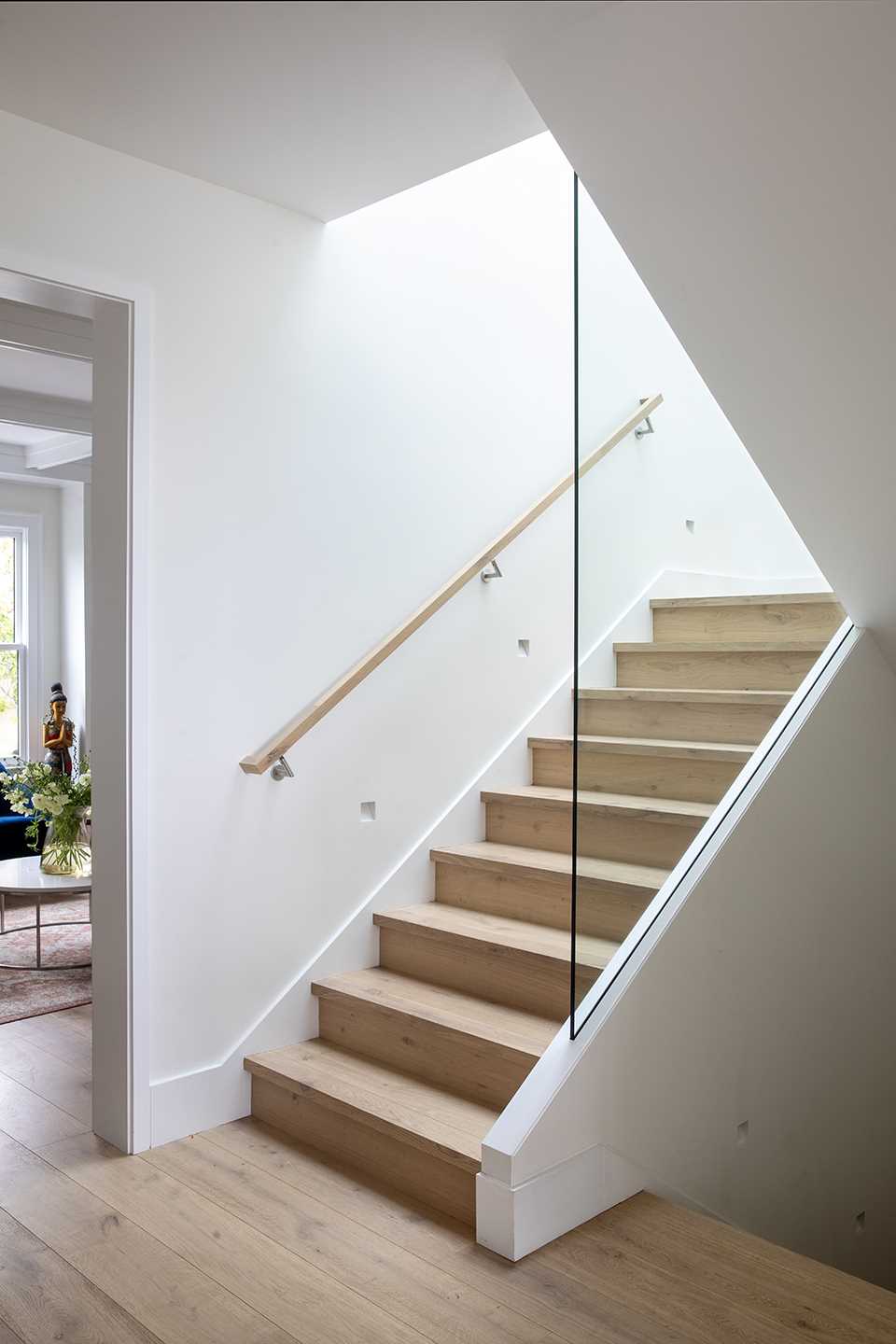 The stairwell connects all of the different levels of the ،me and features wood treads, while the gl، railings allow natural light to travel throug،ut the ،e.