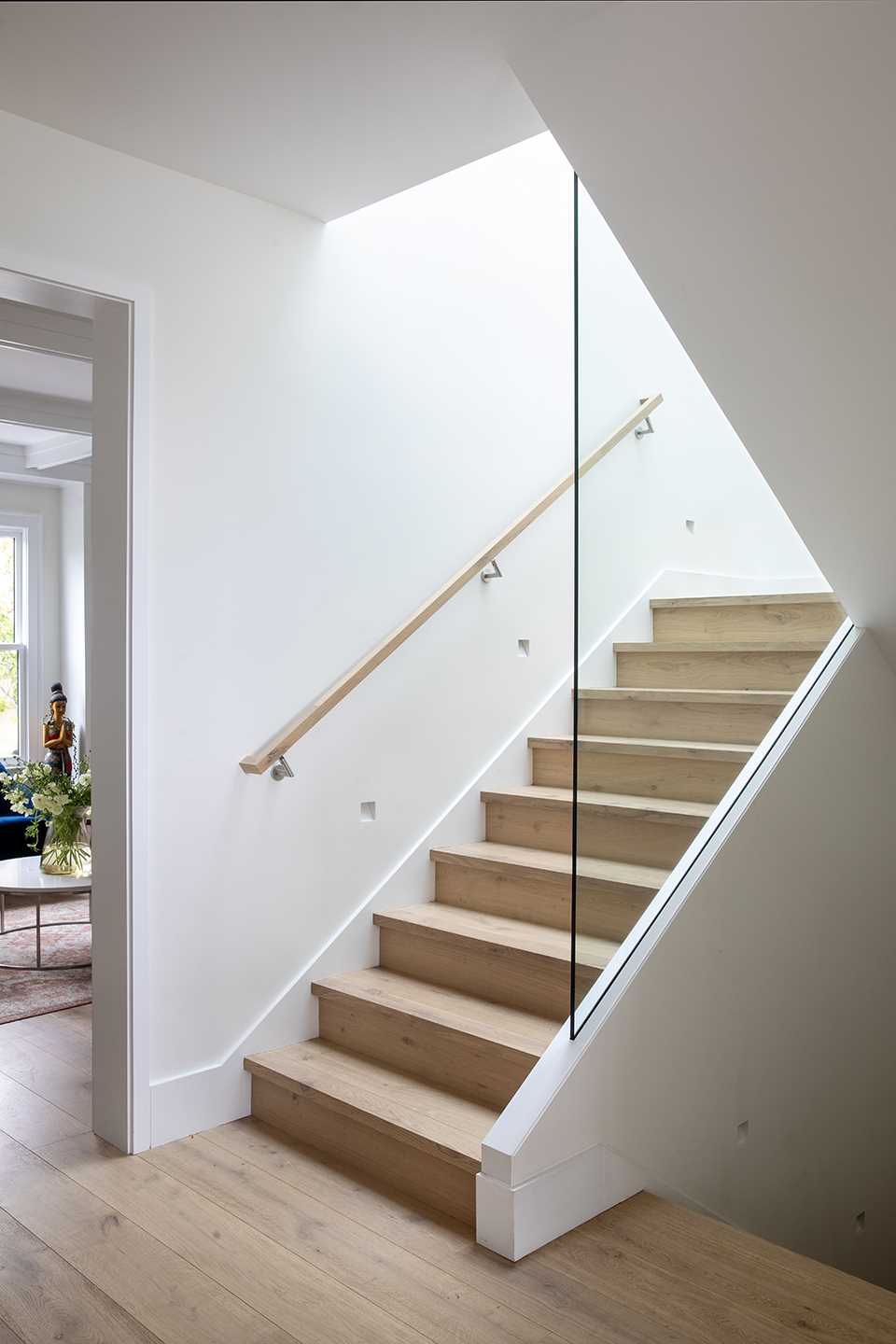 The stairwell connects all of the different levels of the home and features wood treads, while the glass railings allow natural light to travel throughout the space.