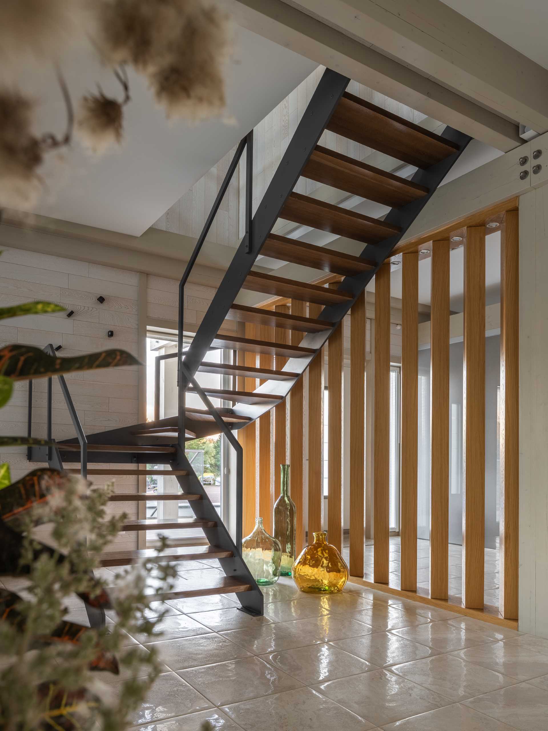 Steel and wood stairs connect the main floor with the upper floor of this home.