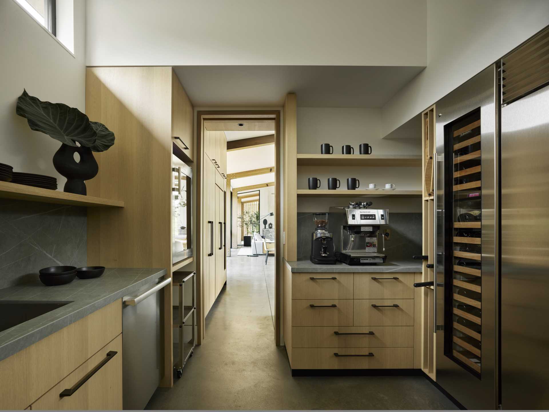 This modern kitchen includes wood cabinets, an island, and a separate walk-in pantry.