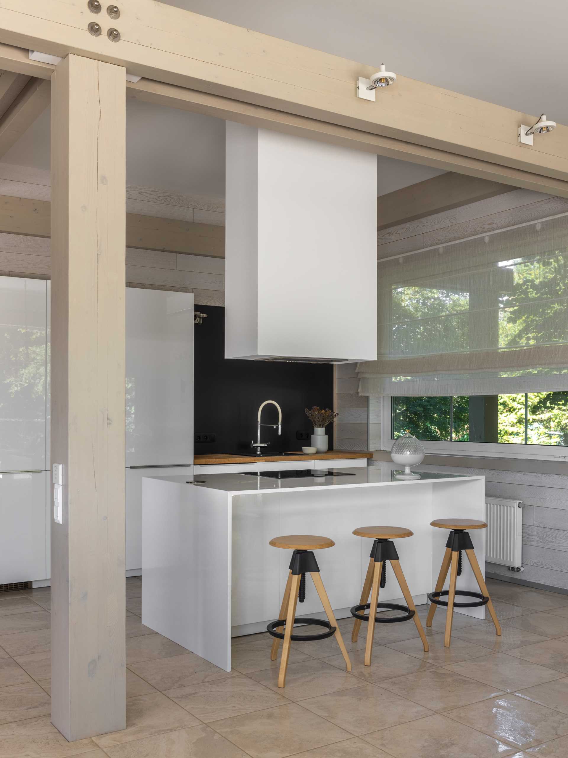 In this kitchen, the white cabinets have been paired with wood accents for a contemporary finish.