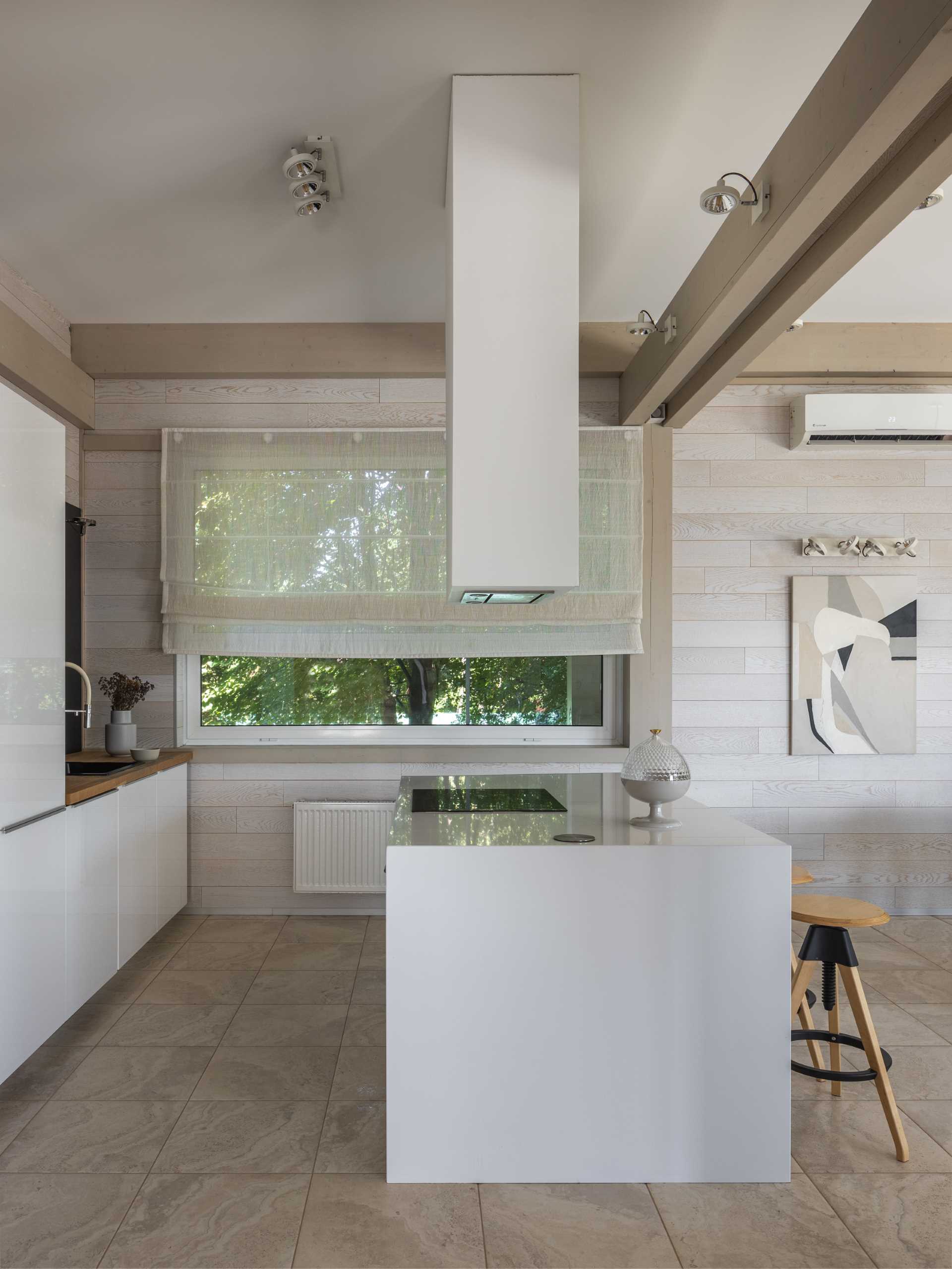 In this kitchen, the white cabinets have been paired with wood accents for a contemporary finish.
