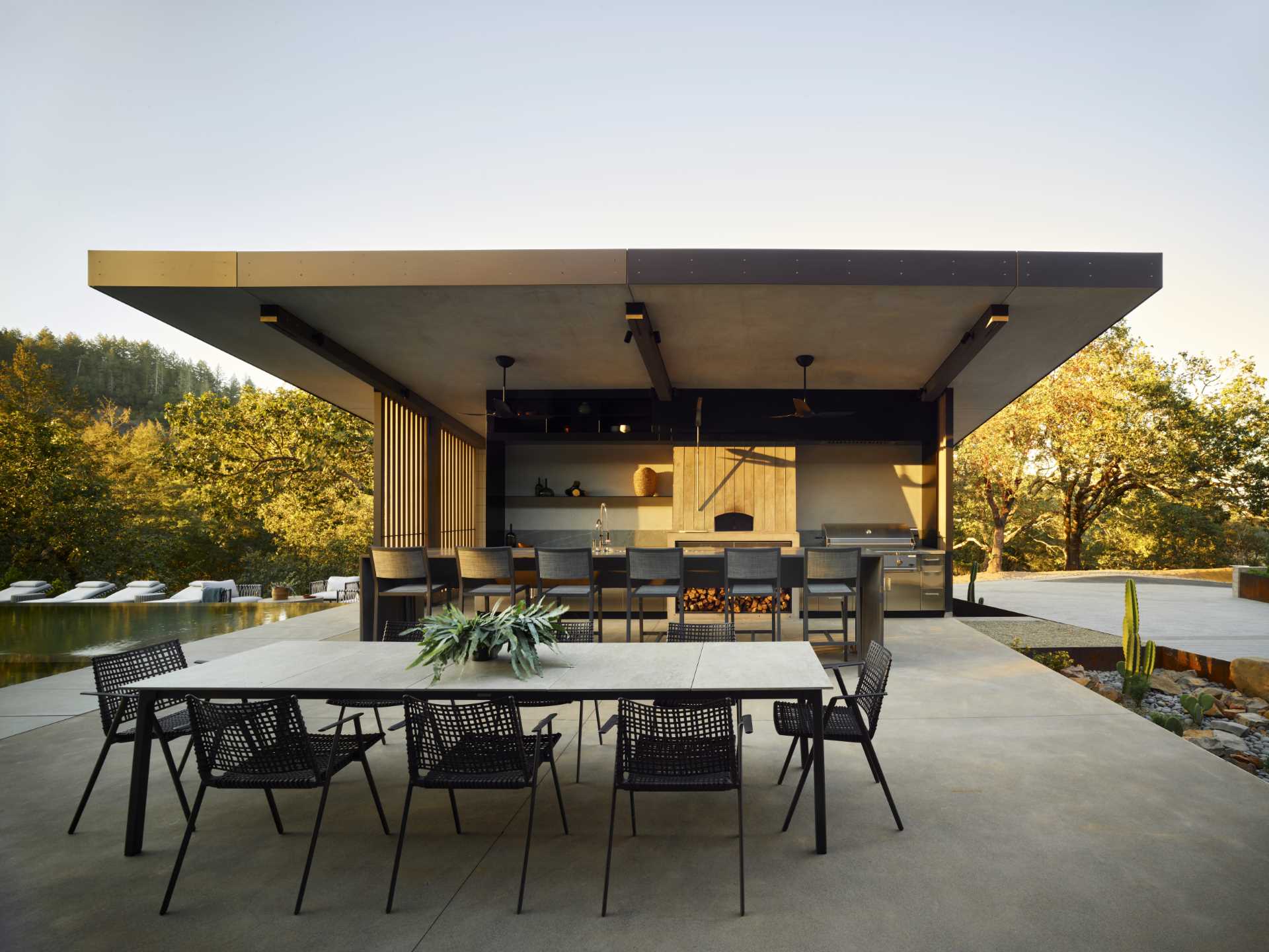 A modern home with a pitched ceiling, exposed wood beams, and expansive outdoor living spaces.