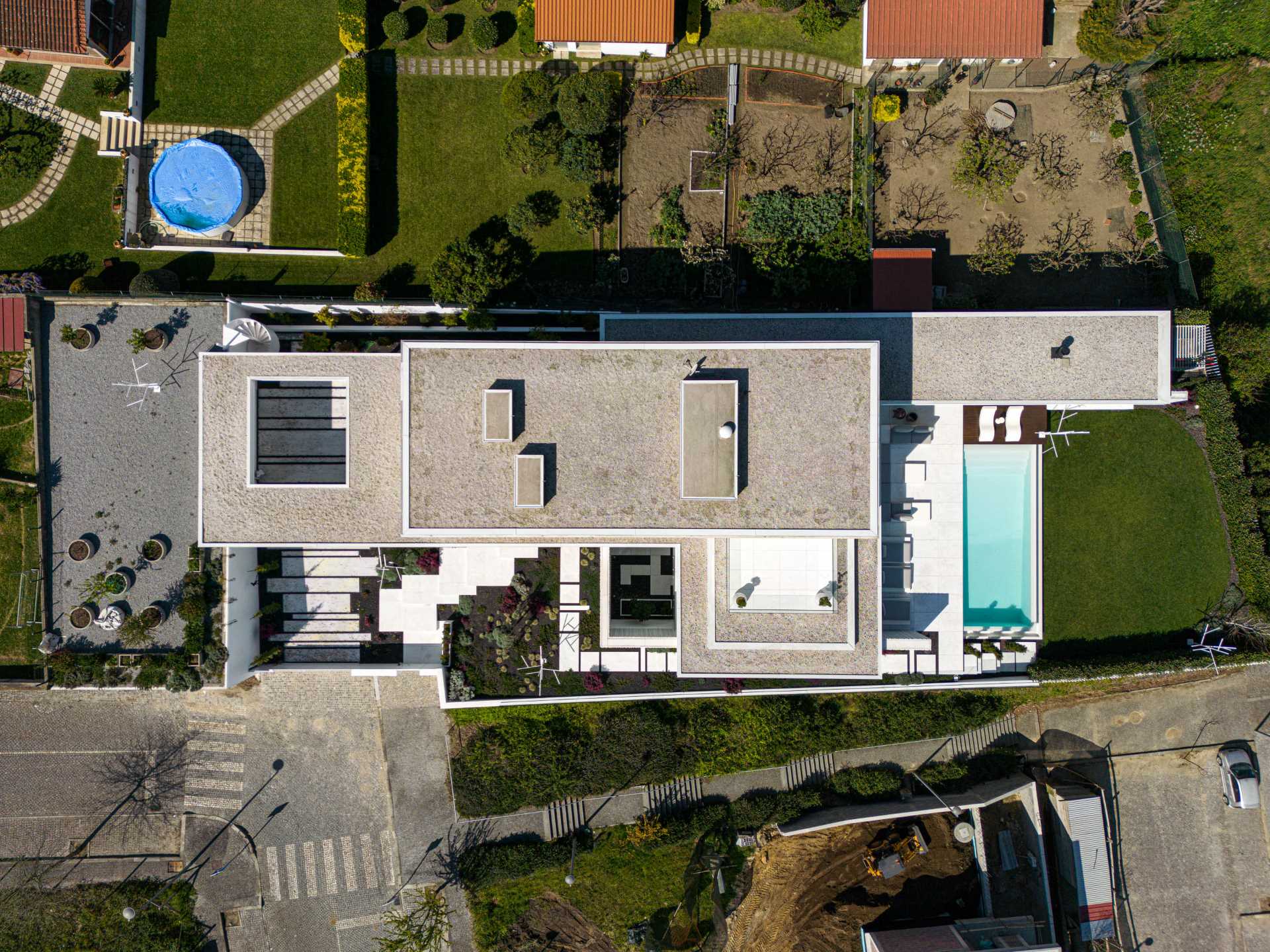 A modern home features an exterior of white concrete with textured accent walls.