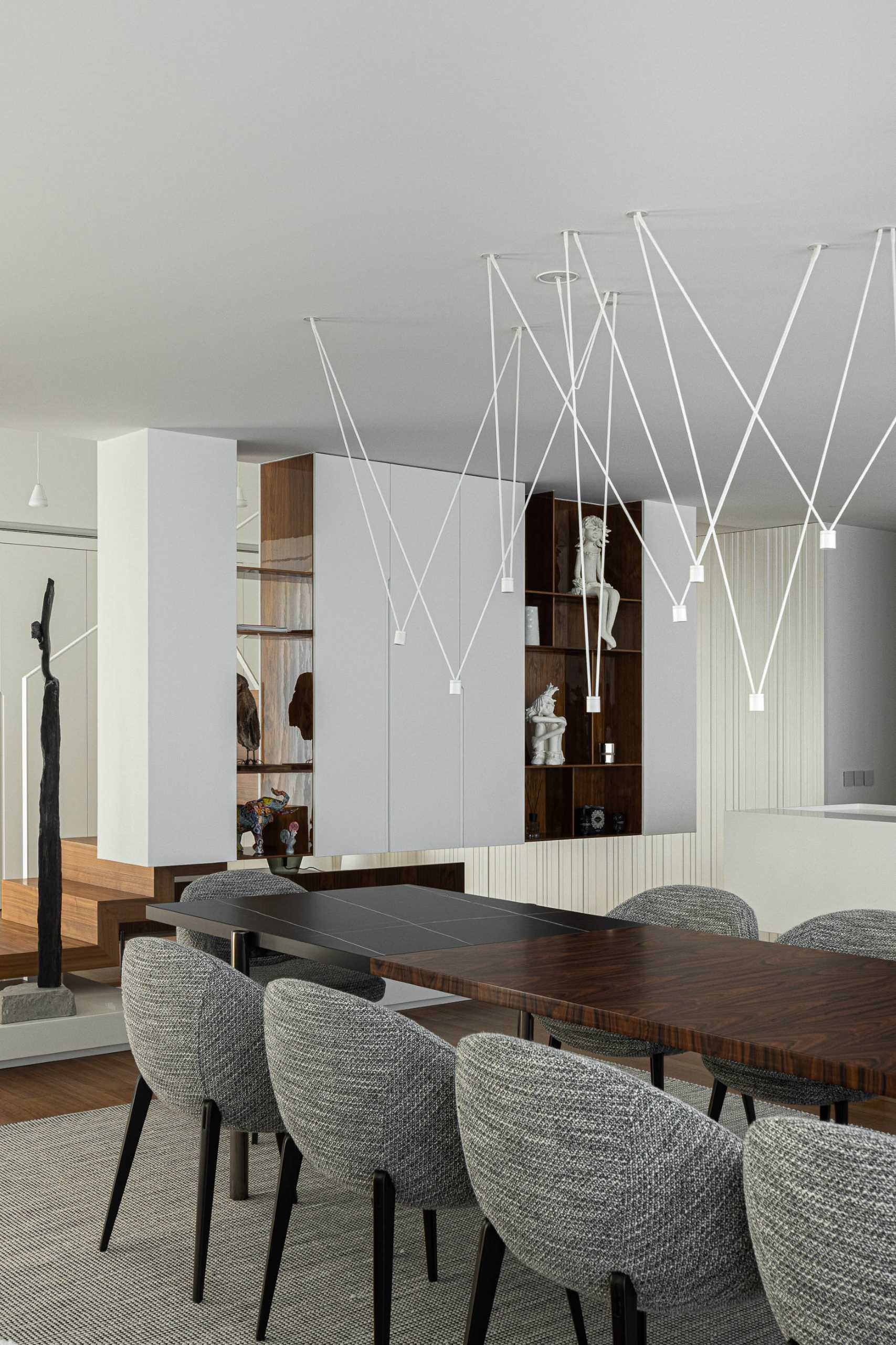 In this modern white kitchen, the textured wall hides the kitchen cabinets, while a sculptural light adds an artistic moment.