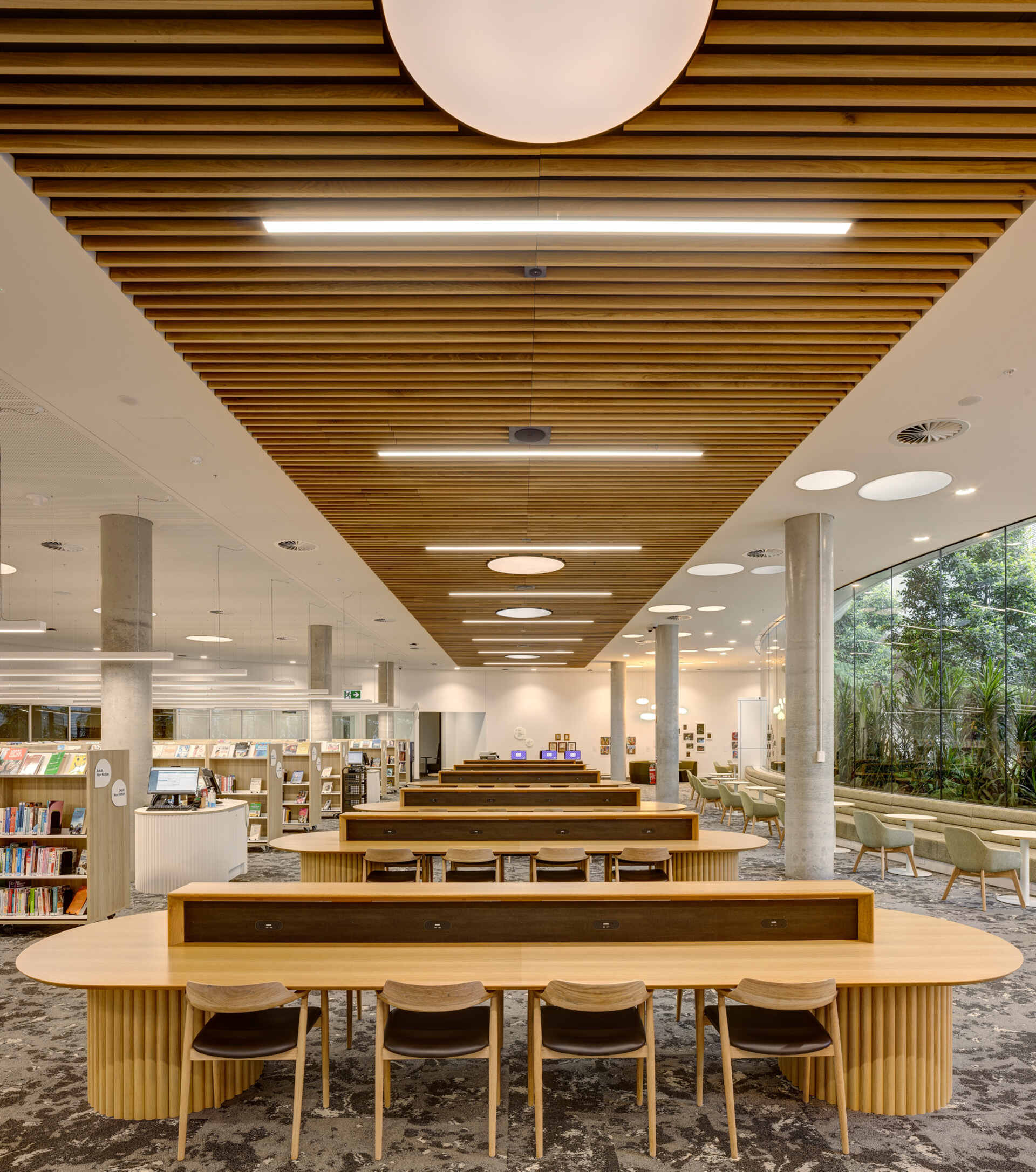 The interior of a modern library with dedicated study area and a reading room.