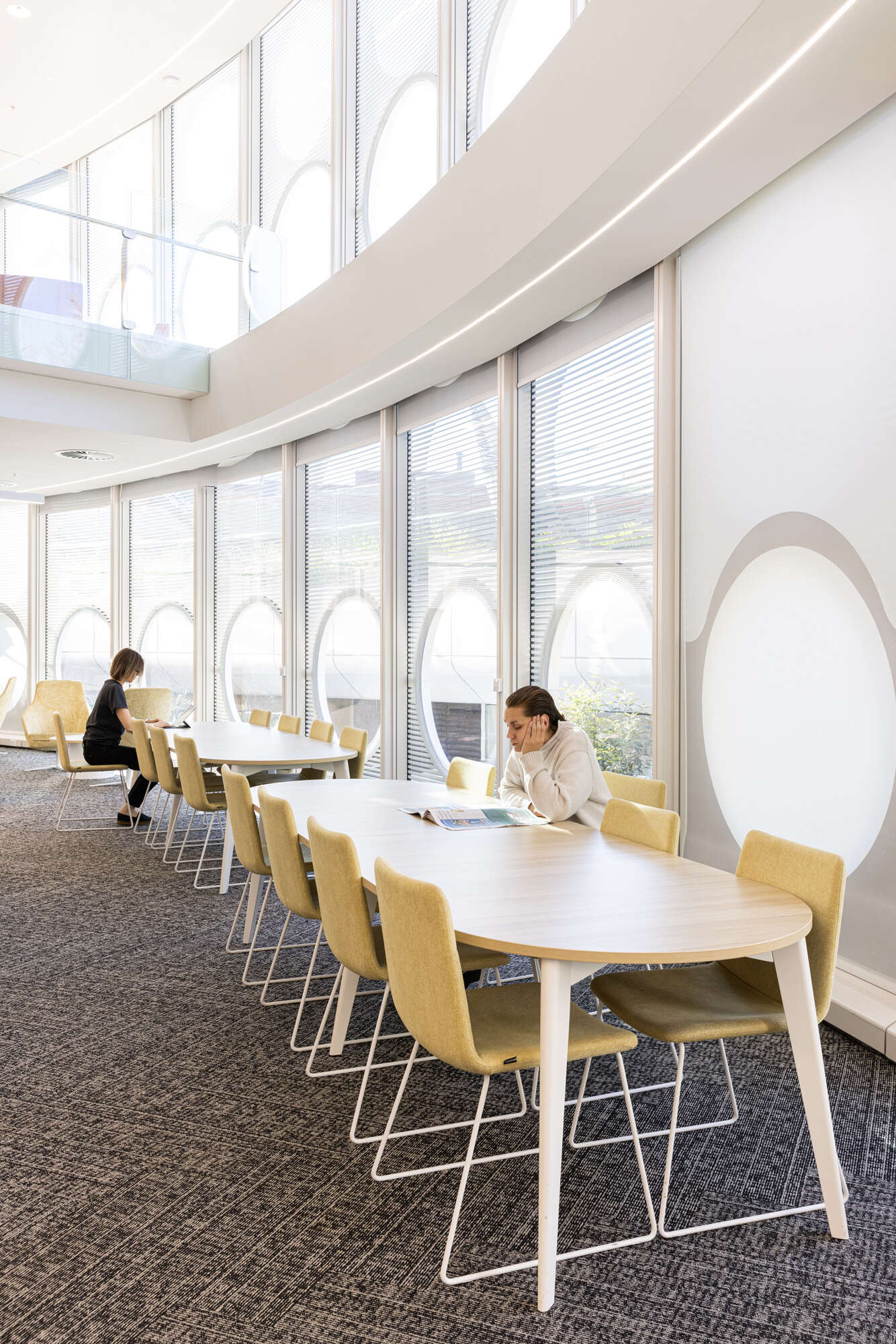 The interior of a modern library with dedicated study area and a reading room.
