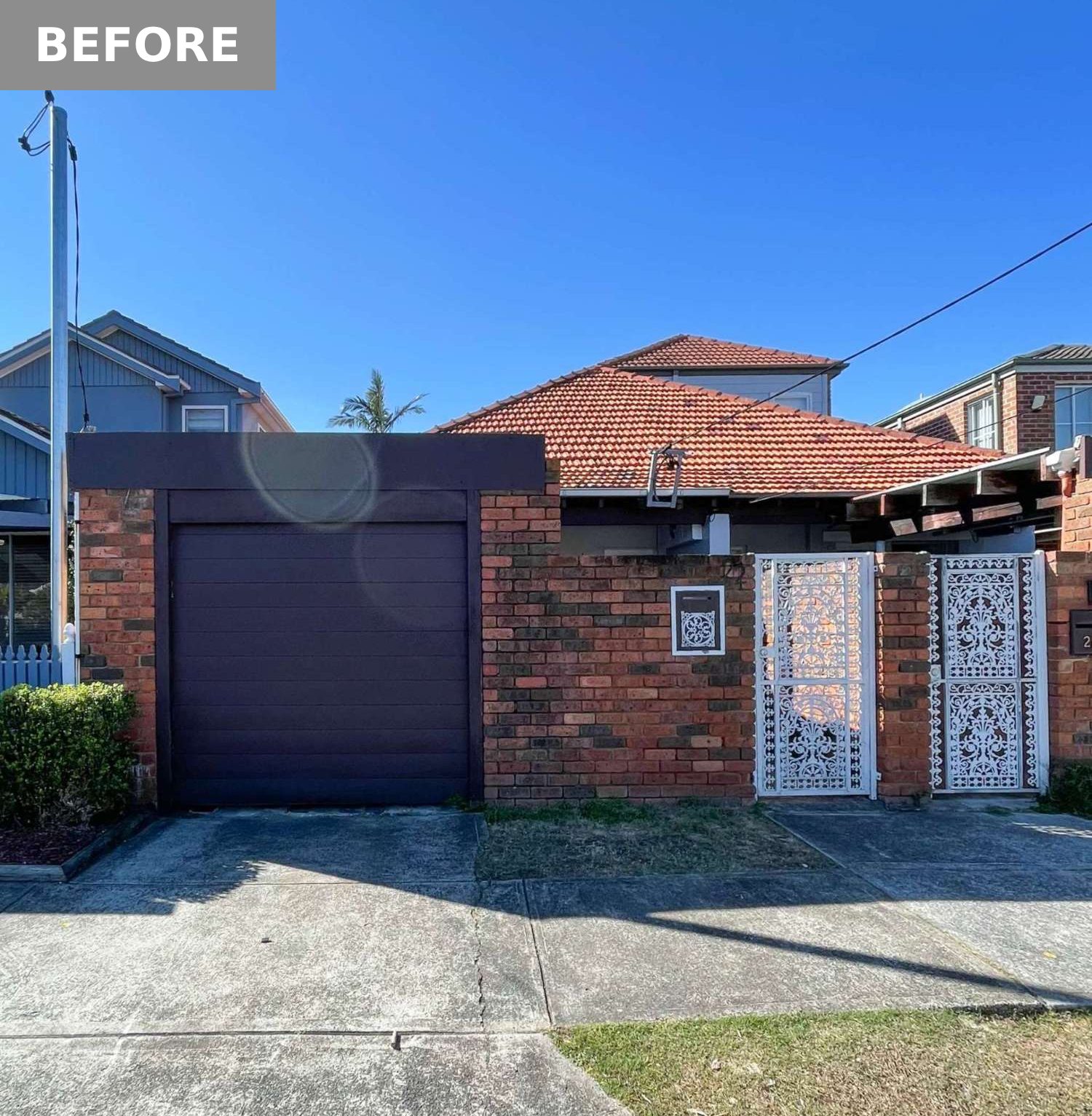 BEFORE - A dated brick facade gets a modern refresh with crisp white render, minimalist lines, and vertical screening. The red tiled roof nods to the past, while a sleek carport and soft landscaping introduce the home's calm, contemporary style.
