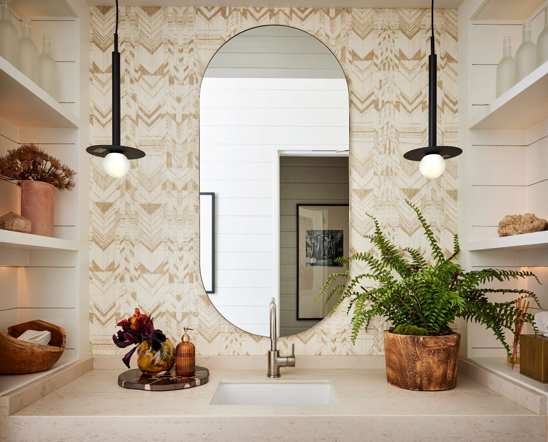 This bathrooms feature grass-like wallpaper, small plants, and dried floral arrangements, extending the calm, nature-inspired feeling throughout the space.