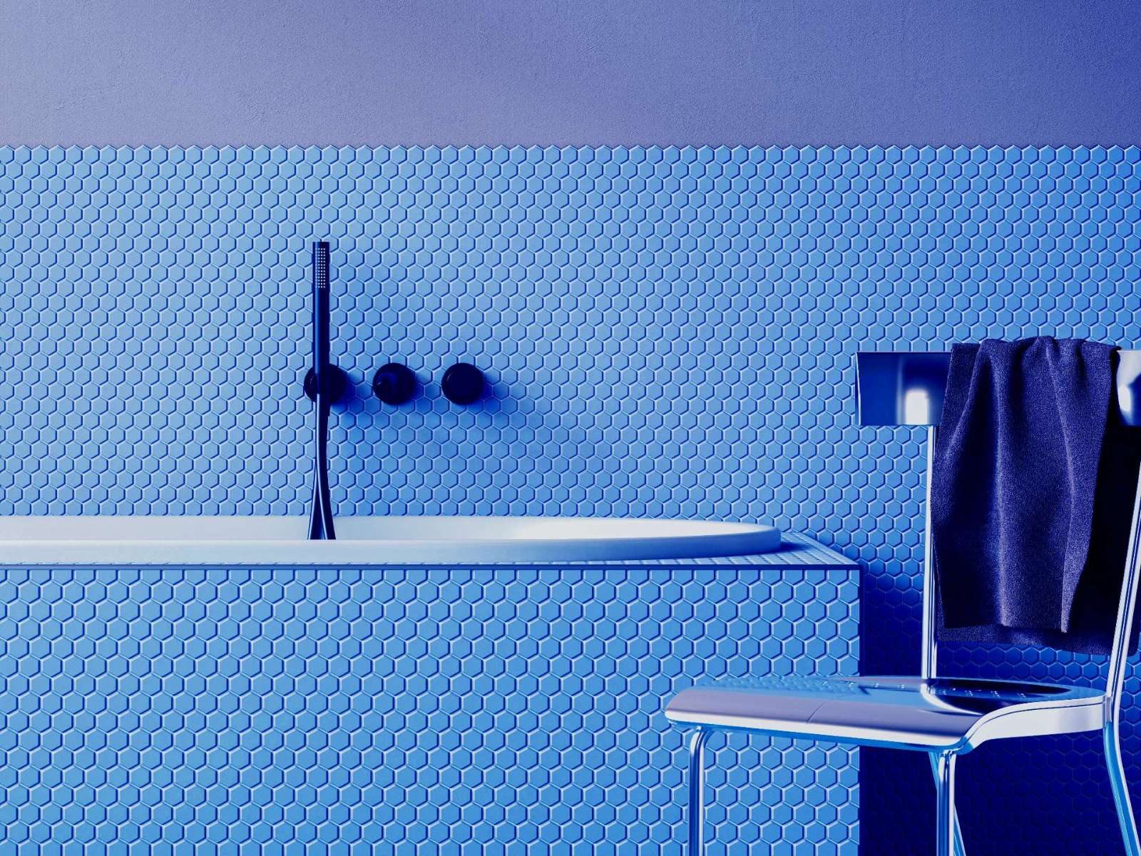 This bold blue bathroom showcases sleek penny tile from floor to tub surround, creating a seamless and modern spa vibe. The matte blue fixtures and chrome chair complete the minimalist look with high-impact style.