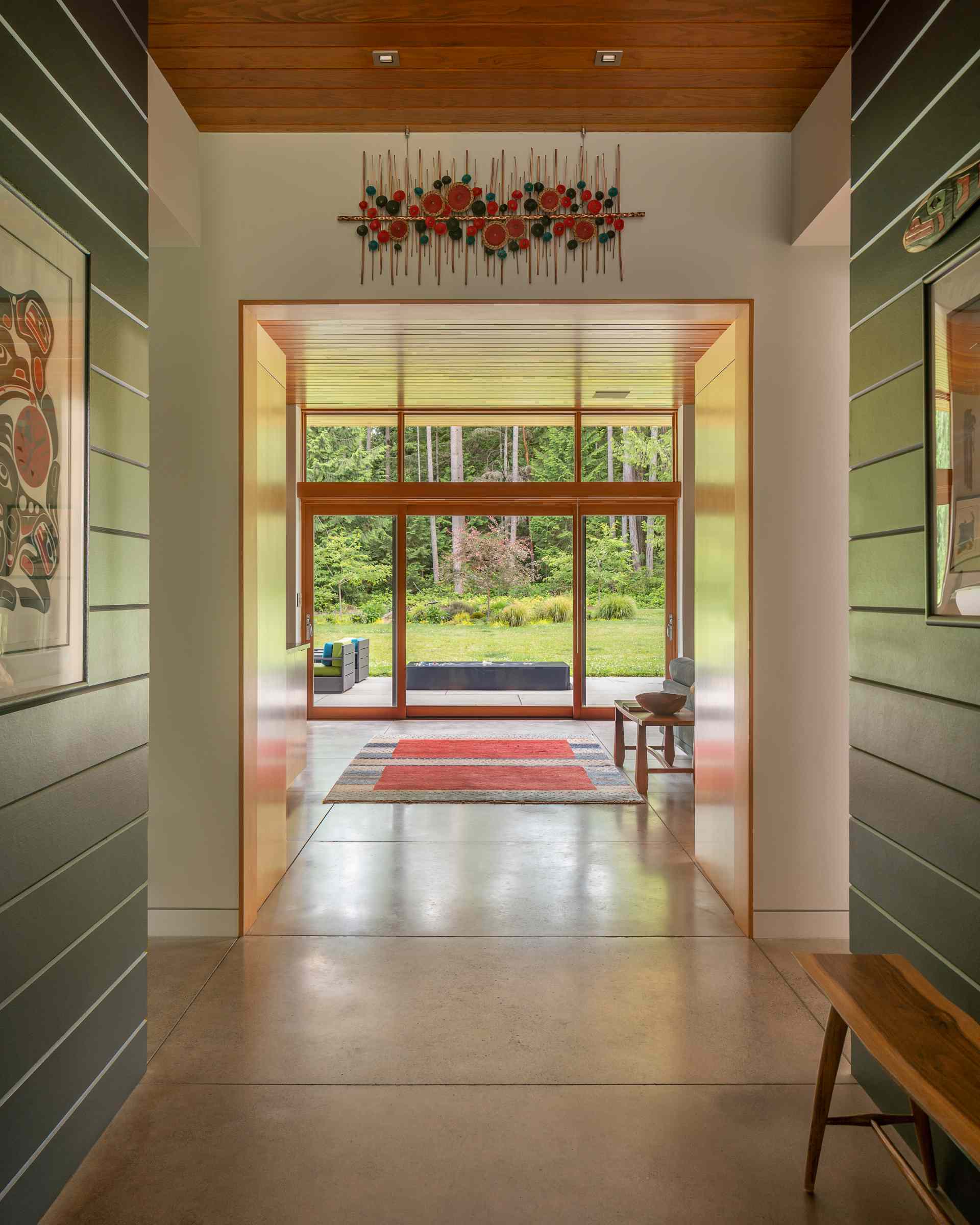 Inside this modern home, the entryway has a direct view of the patio and landscape.