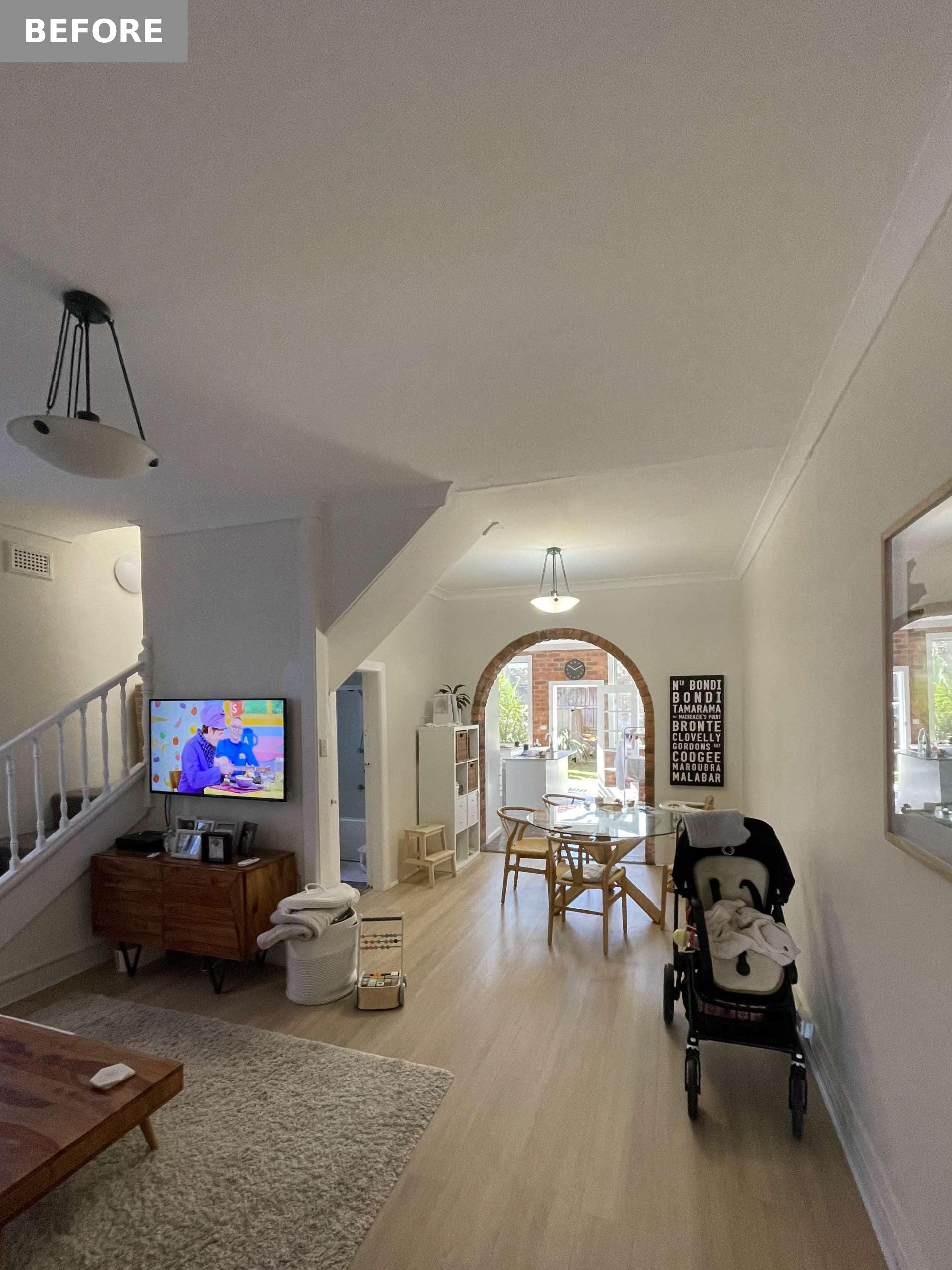 An arched brick opening broke the visual flow between the kitchen, living, and dining areas, acting as a visual and spatial barrier that segmented the open-plan layout into disconnected zones.