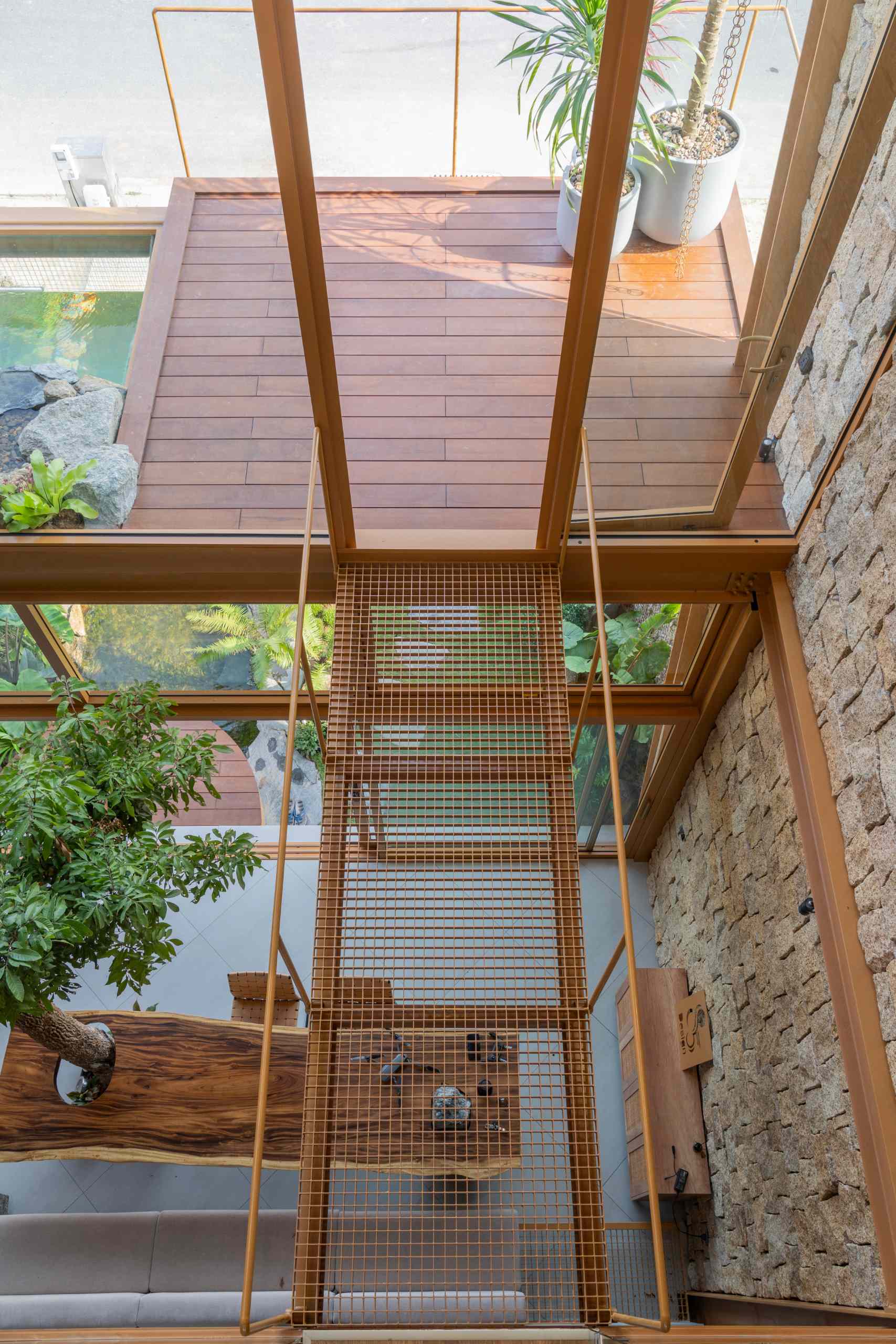 Suspended walkways framed in glass and steel weave through the home, connecting spaces while adding a sense of lightness and openness to the interior.