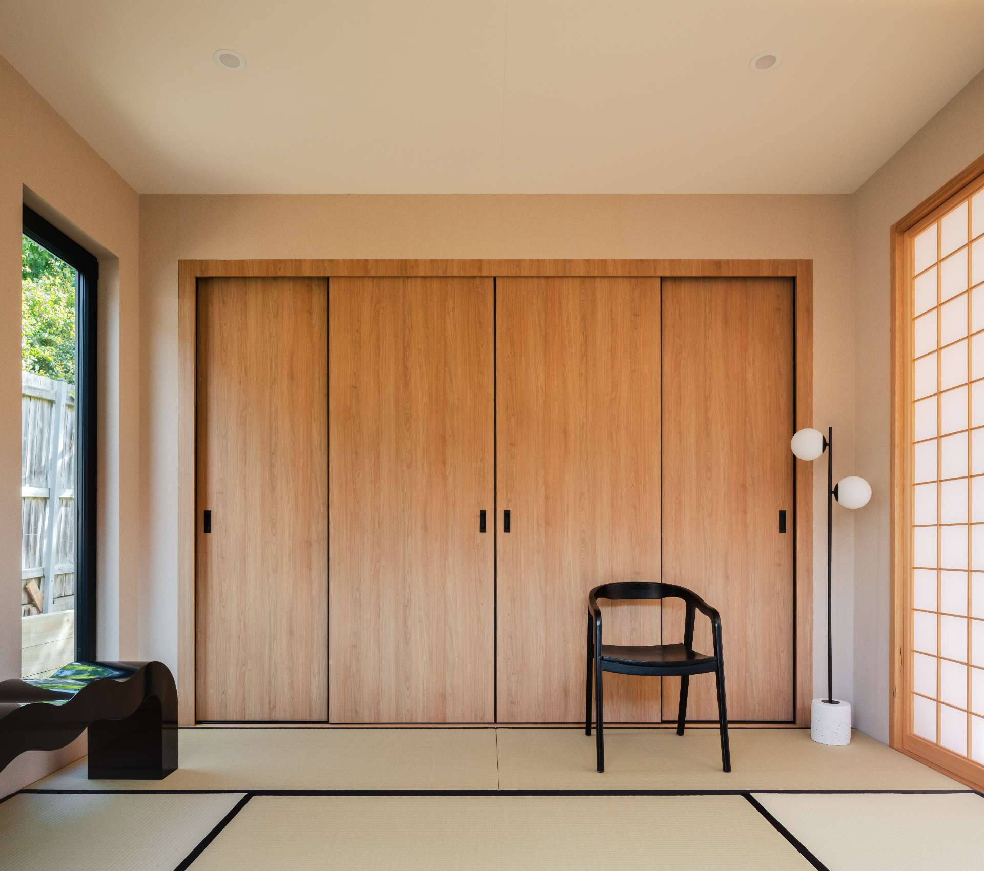 A serene fusion of traditional and modern, tatami flooring and shoji screens frame a sunlit room.