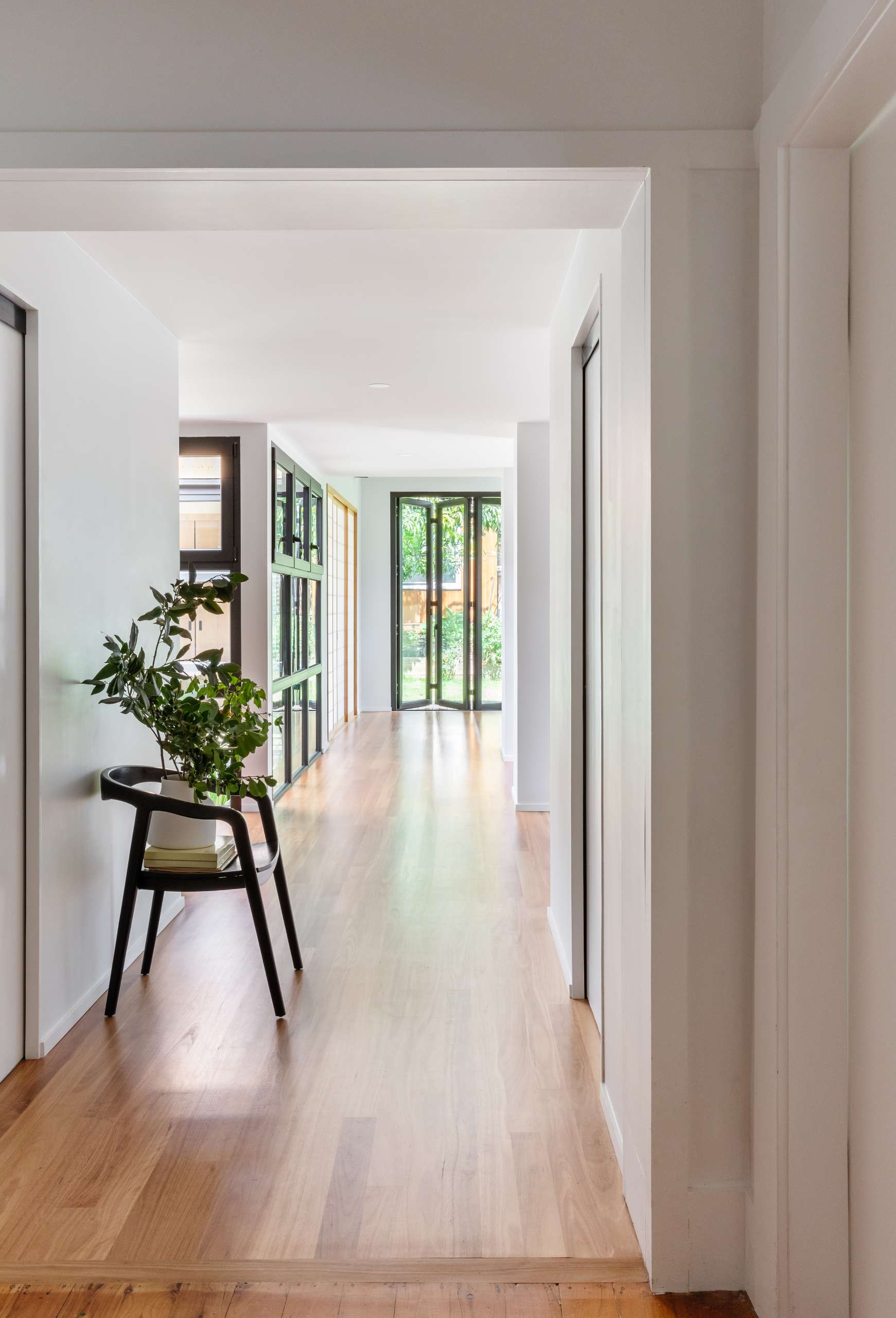 Movement through the new wing is guided by a simple hallway with wood floors and white walls.