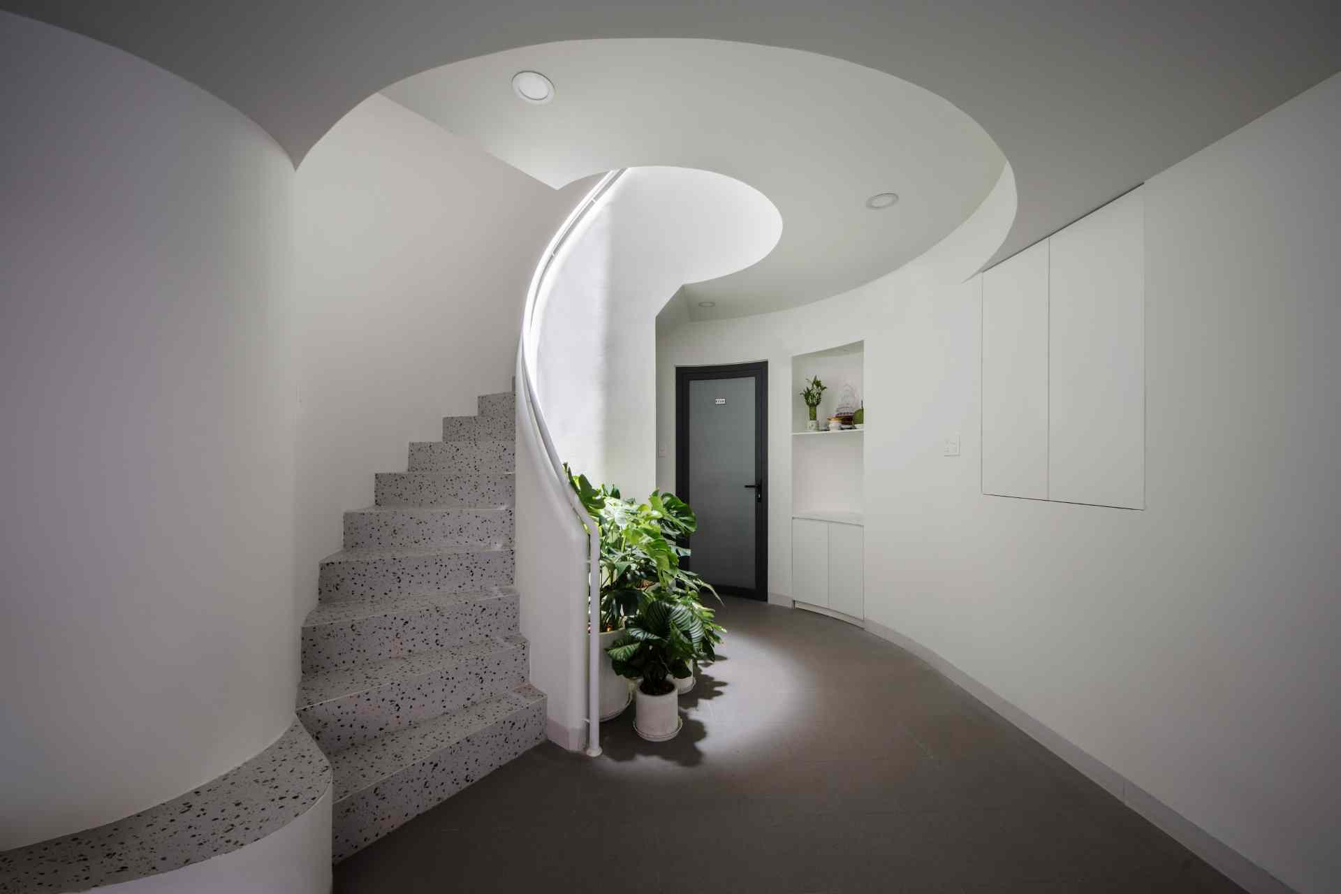 A modern apartment building has a central staircase.