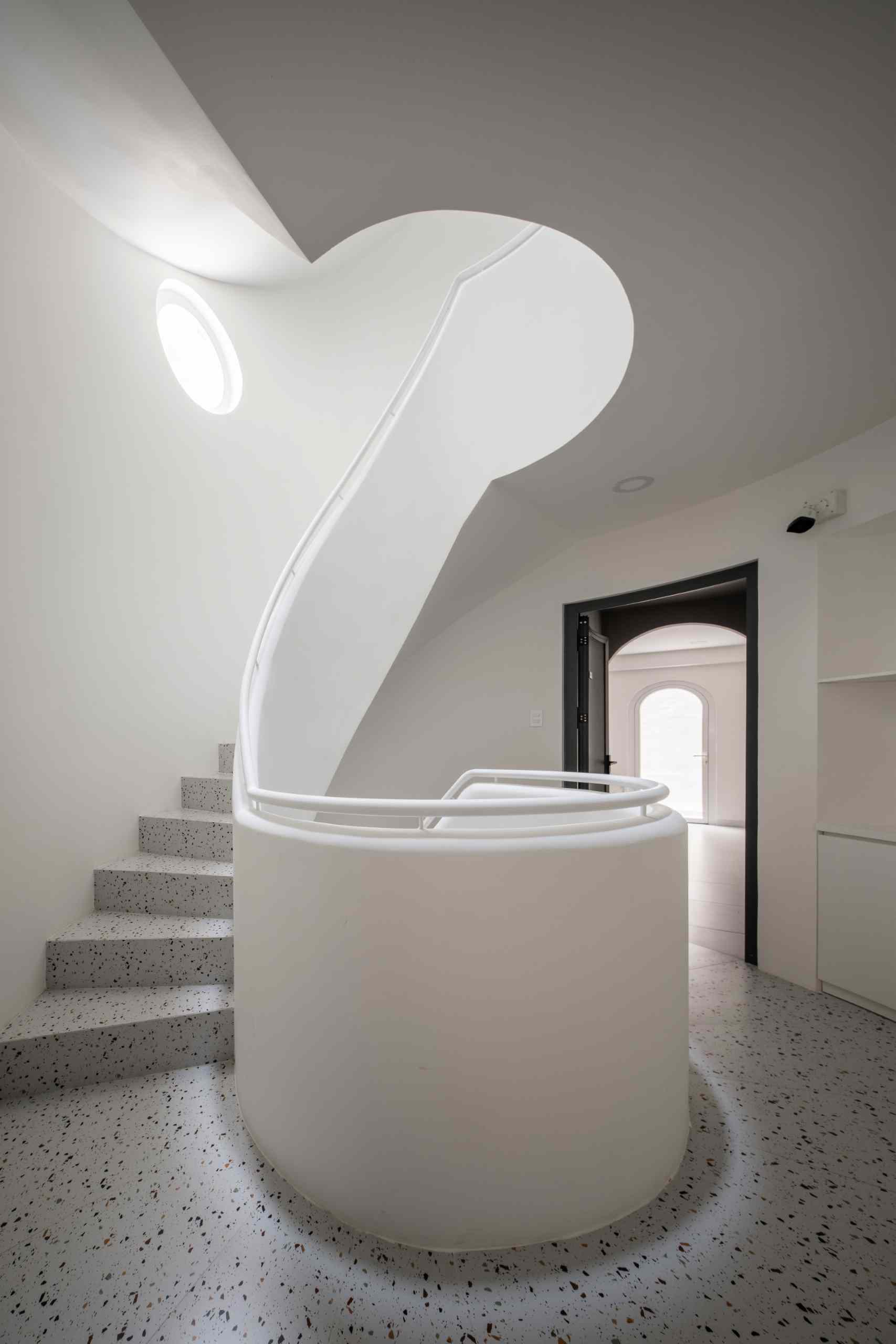 A modern apartment building has a central staircase.