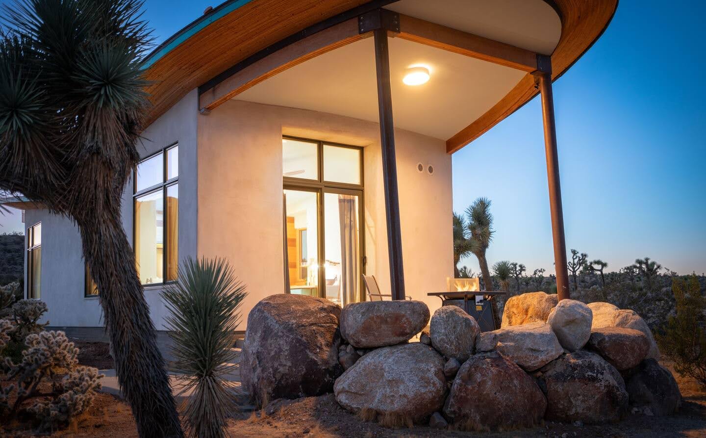 A radical strawbale cabin in the desert, has a butterfly roof and is covered in a natural lime plaster.
