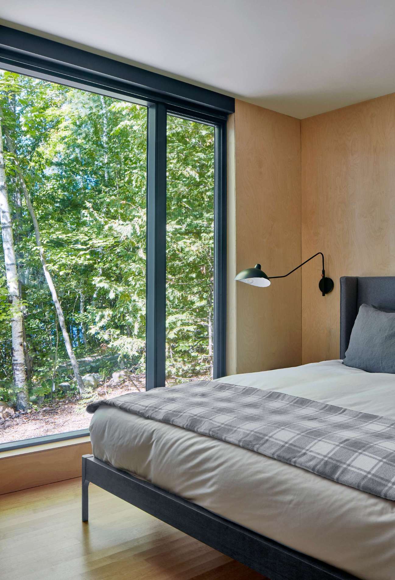 The colors and materials of this bedroom match the modern cottage aesthetic found throughout the home.